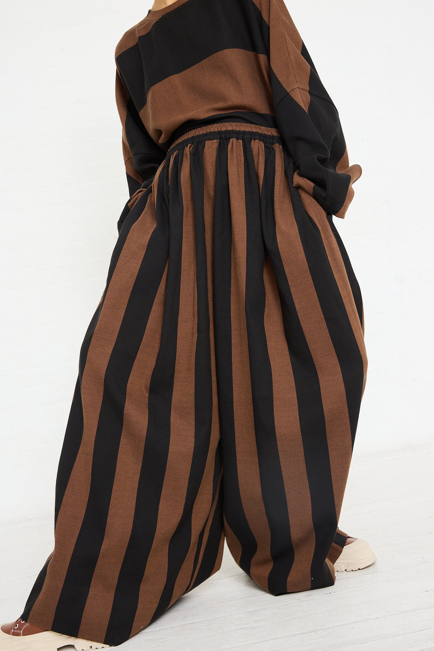 Woman wearing Marrakshi Life Drawstring Pleated Pant in Black and Brown Stripe, viewed from behind.