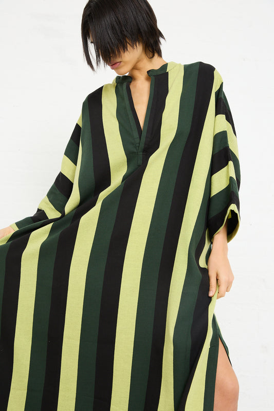 Woman in a Marrakshi Life Nero Collar Caftan in Green Stripe with v-neckline and short hair, posing against a white background.