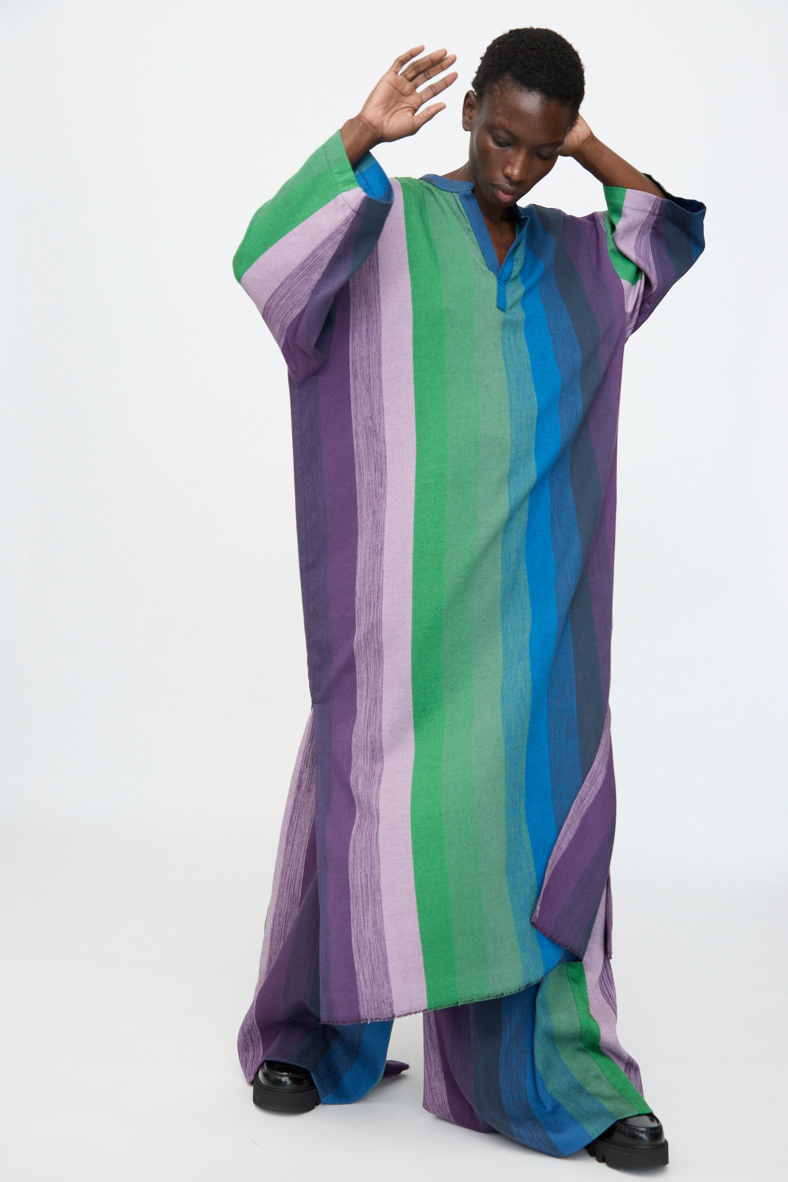 A model wears the Marrakshi Life Nero Collar Caftan in Stripe Multi—an oversized cotton piece featuring green, purple, and blue stripes—set against a plain white background.