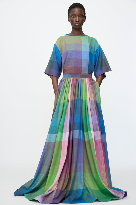 A person wears the Marrakshi Life Puffer Skirt in Plaid Multi, a floor-length skirt featuring a colorful large plaid pattern in blue, green, purple, and pink, set against a plain background.