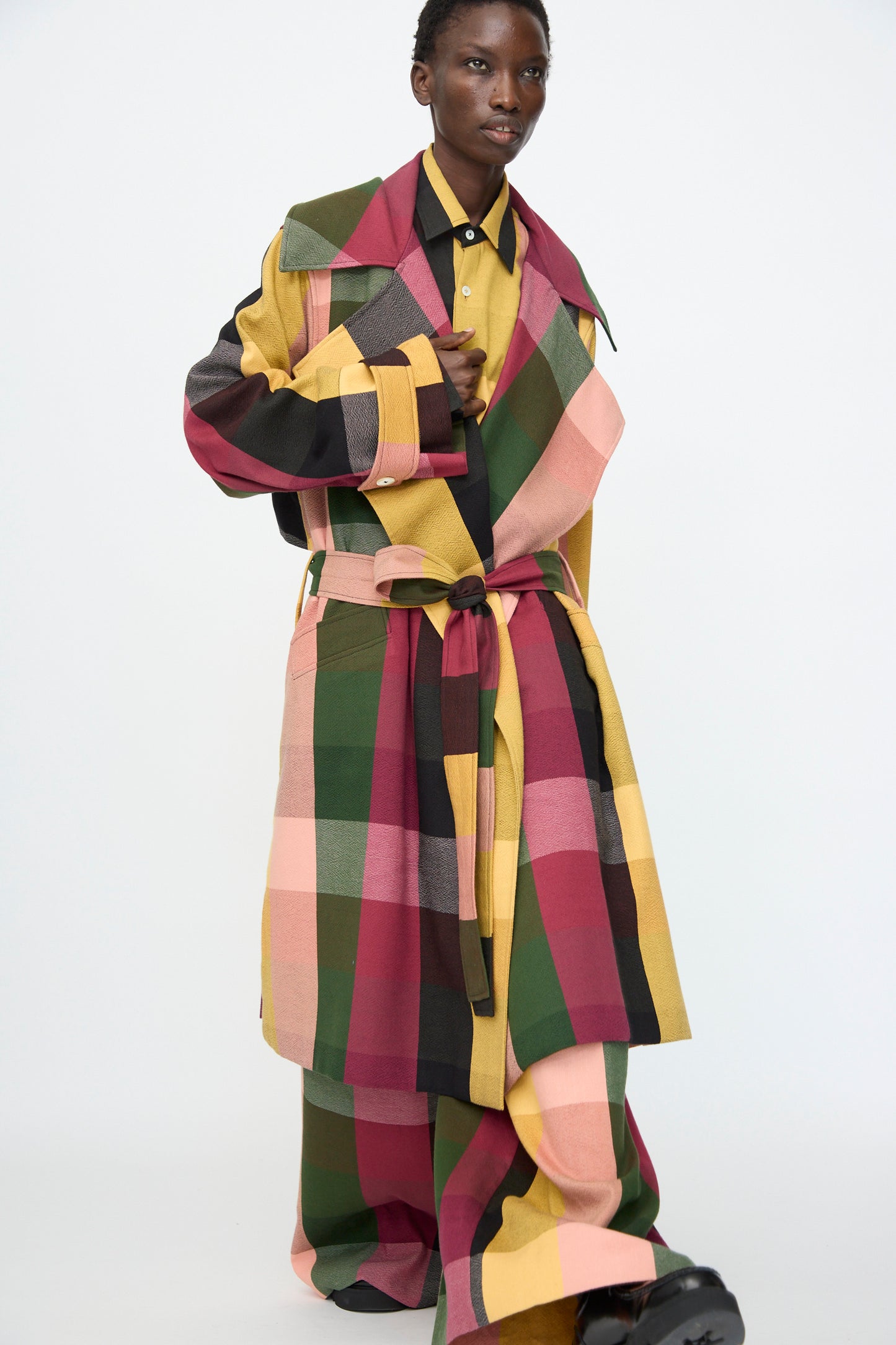 Model wears the Marrakshi Life Trench Coat in Plaid Multi with matching wide-leg pants, both featuring a bold, multicolored pattern, set against a plain white background.