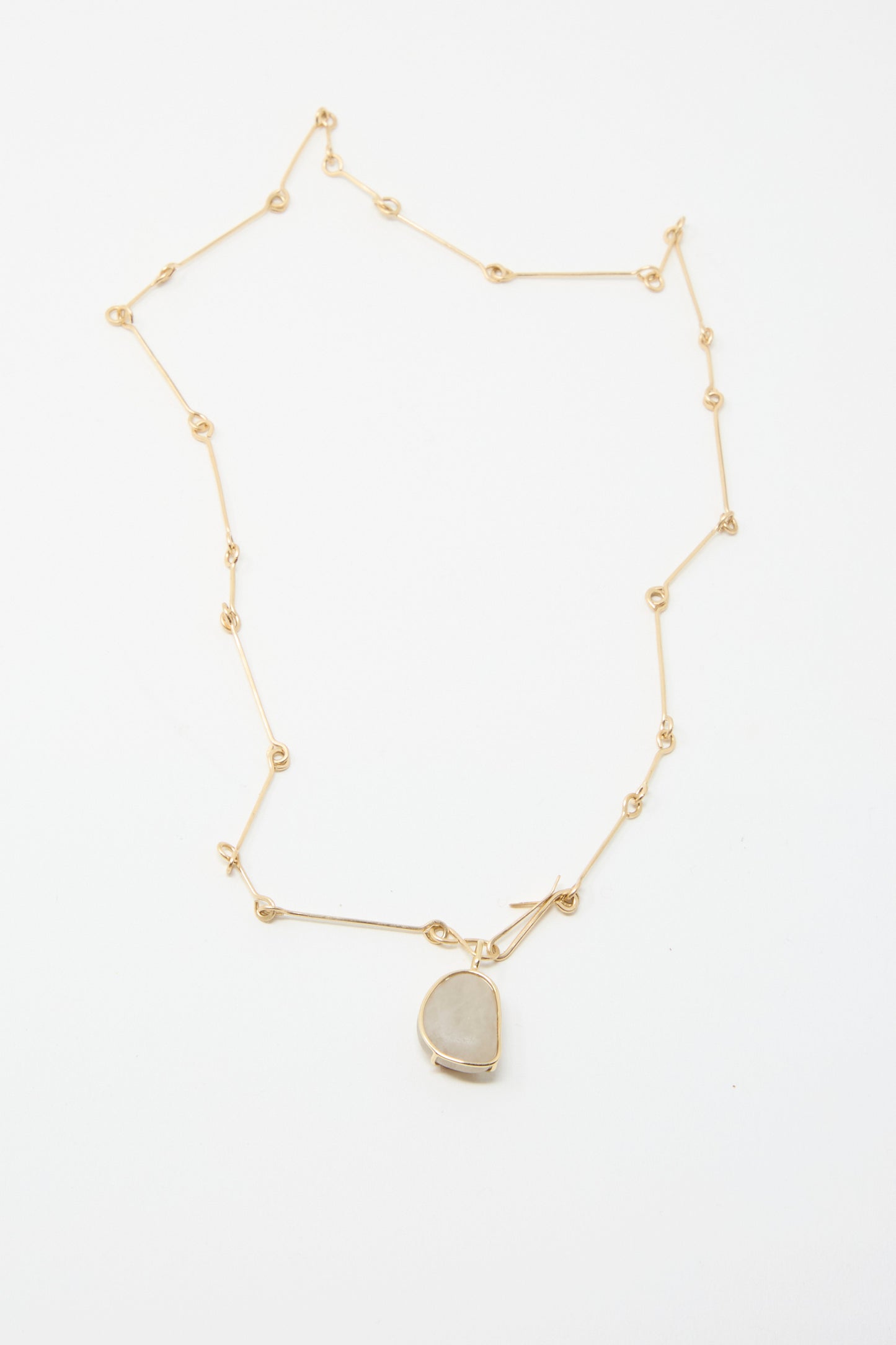 The Mary MacGill 14K Floating Bone Chain Necklace, showcasing a pendant in Block Island Stone on a gleaming gold chain against a pristine white background.