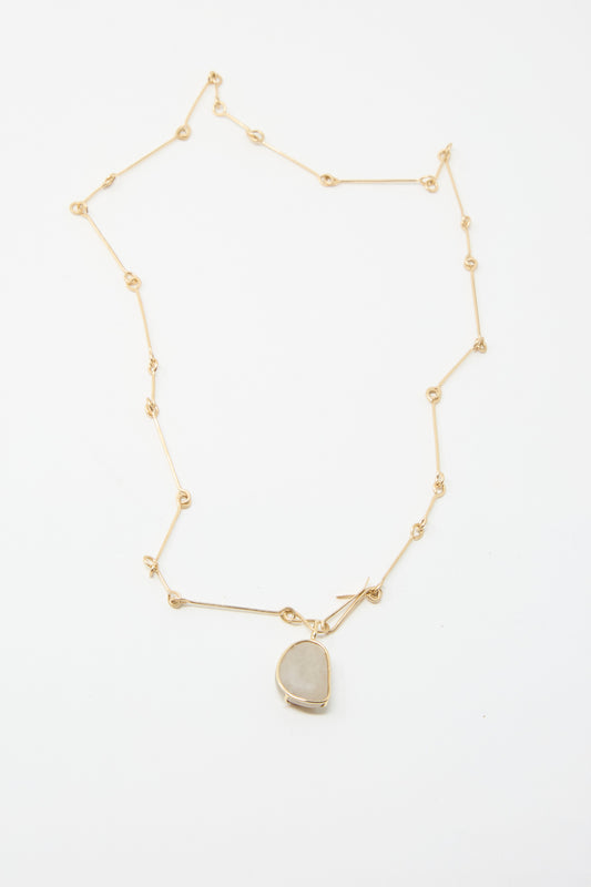 The Mary MacGill 14K Floating Bone Chain Necklace, showcasing a pendant in Block Island Stone on a gleaming gold chain against a pristine white background.