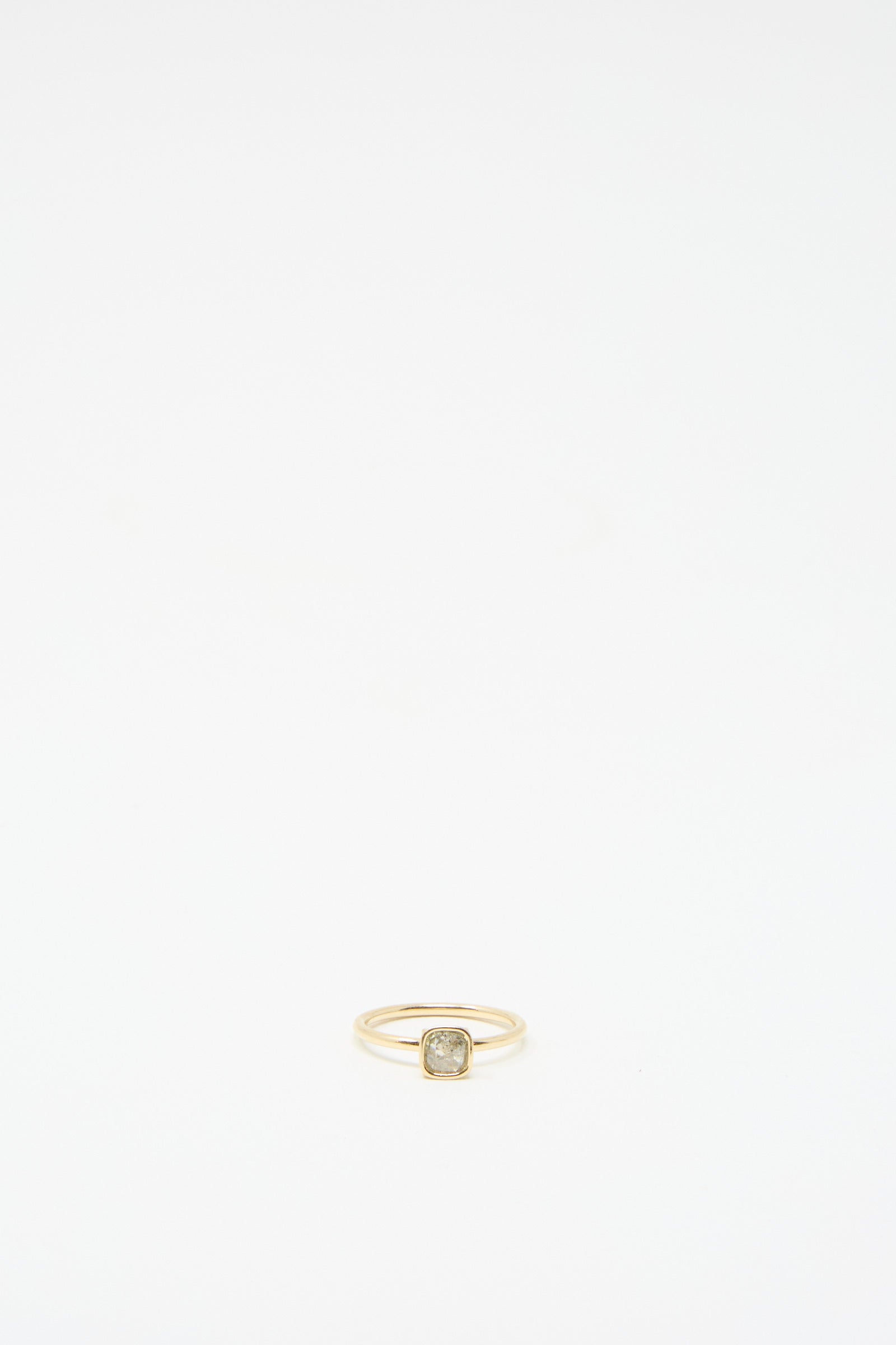 The 14K Floating Ring by Mary MacGill, featuring a square setting with a small salt and pepper rose cut mineral diamond, is displayed against a plain white background.