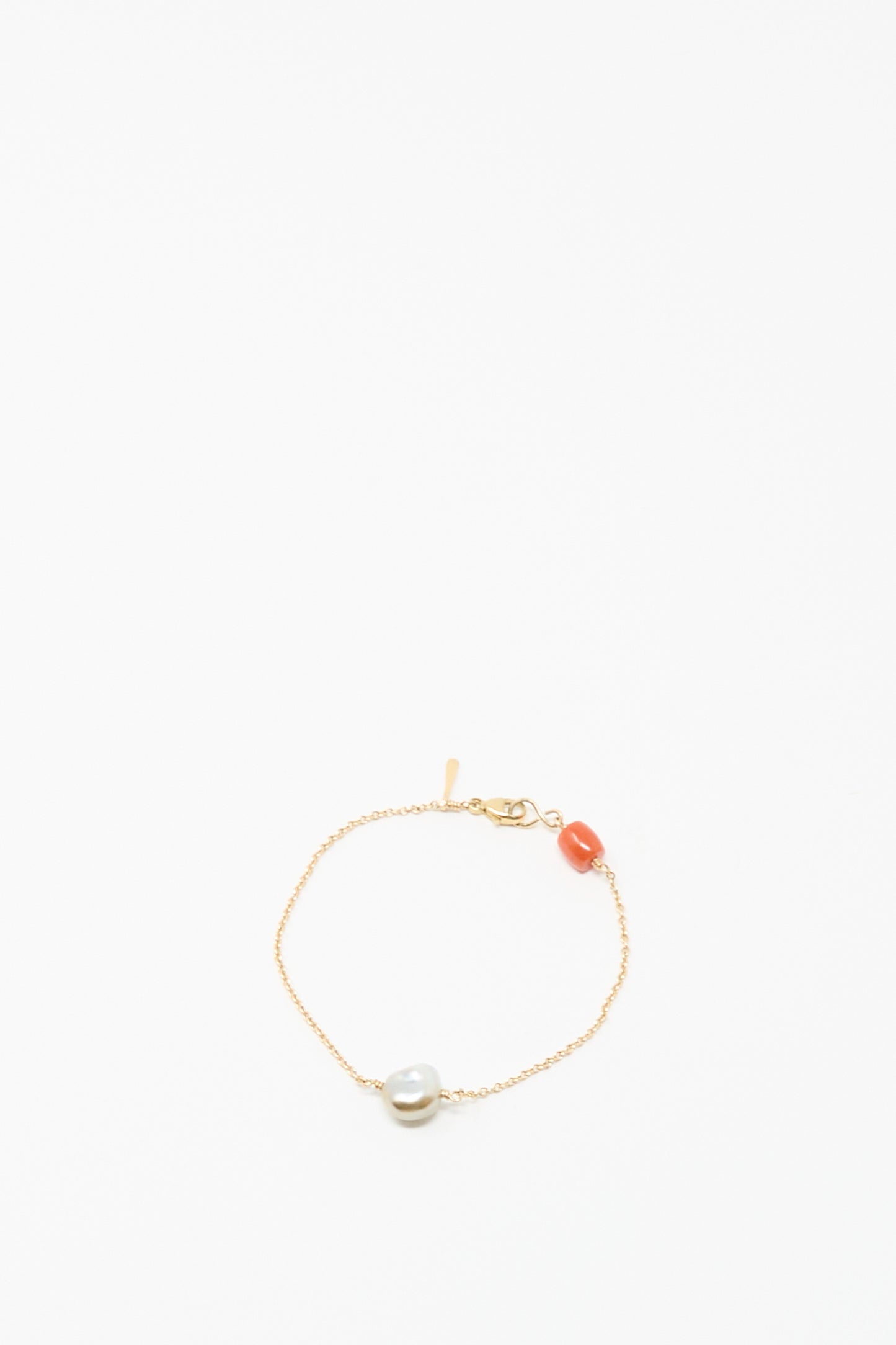 The Mary MacGill 14K Stone Chain Bracelet in Coral and Keshi pearl features a single white Keshi pearl and orange coral bead on a delicate gold chain, shown against a plain white background.