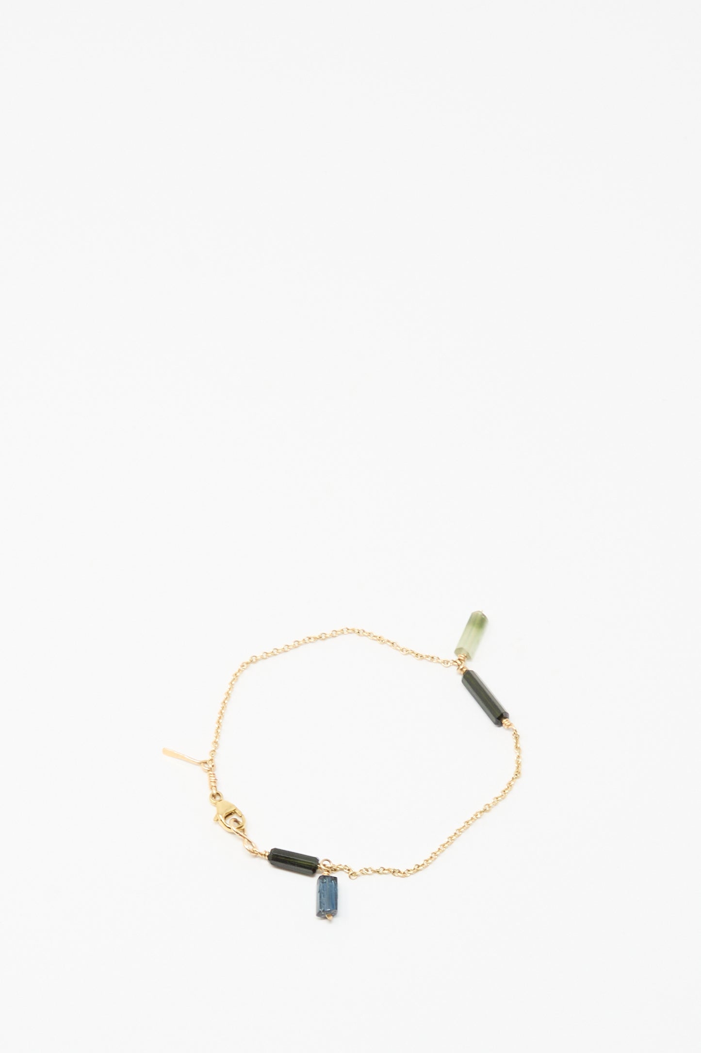 The Mary MacGill 14K Stone Chain Bracelet in Multi Tourmaline features three small rectangular green and blue tourmaline charms, showcasing modern handmade design on a white background.