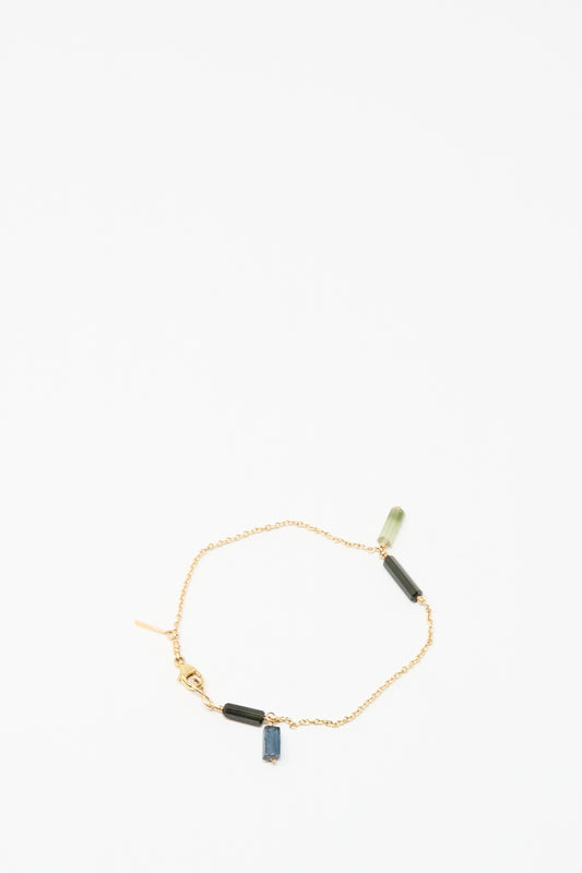 The Mary MacGill 14K Stone Chain Bracelet in Multi Tourmaline features three small rectangular green and blue tourmaline charms, showcasing modern handmade design on a white background.