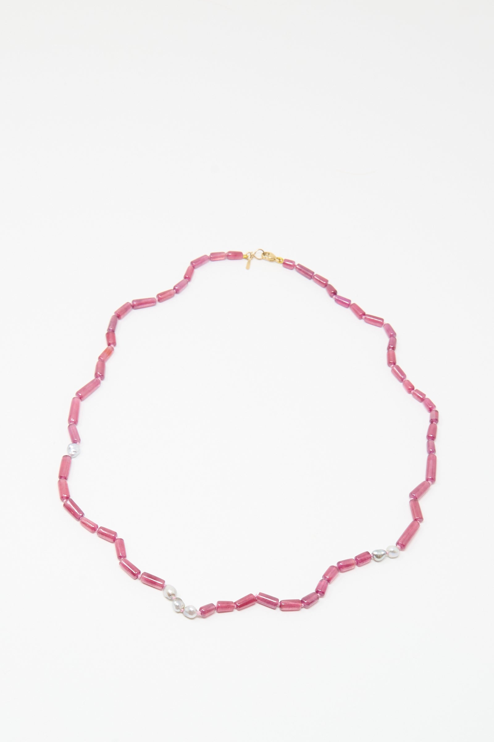 The Mary MacGill 14K Stone Layering Necklace features cylindrical ruby beads, small Keshi pearls, and a gold clasp, arranged in an elegant oval on a white background.