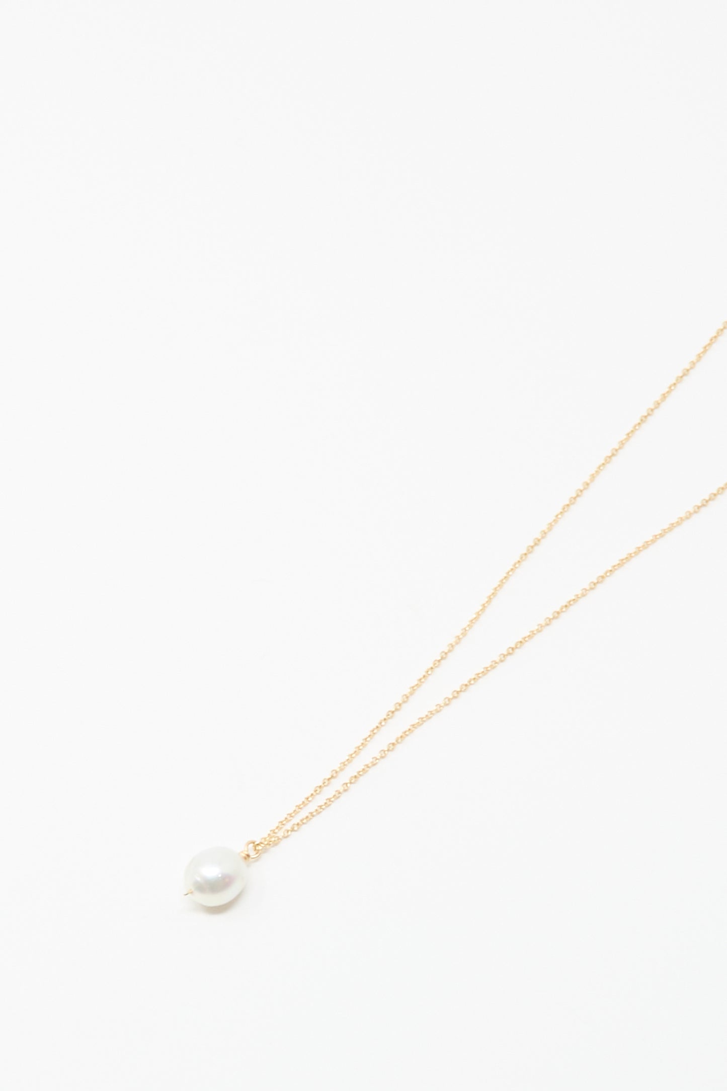 The Mary MacGill 14K Tahitian Pearl Drop Necklace in White is a delicate handmade gold chain featuring a single white pearl pendant, shown on a plain white background.