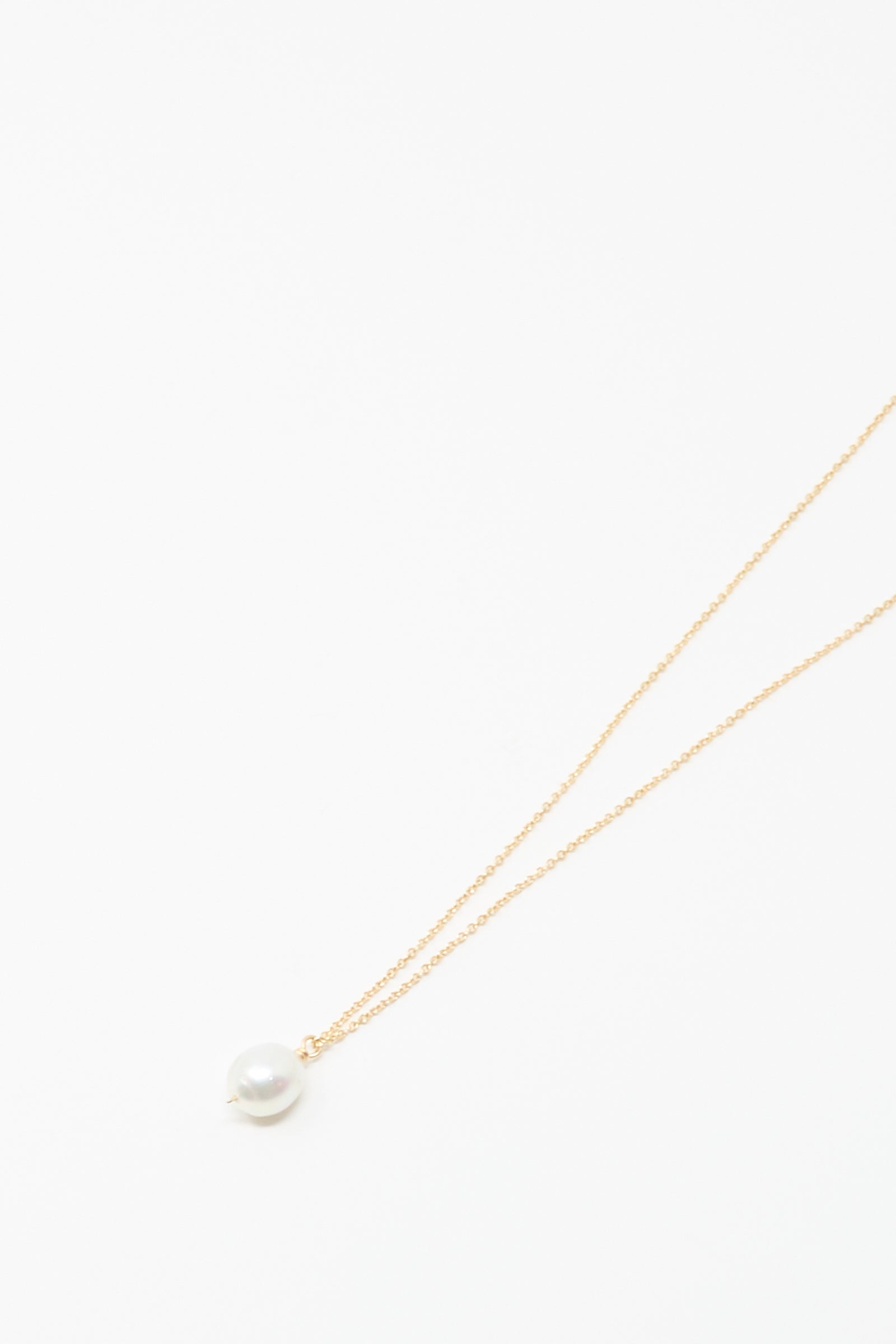 The Mary MacGill 14K Tahitian Pearl Drop Necklace in White is a delicate handmade gold chain featuring a single white pearl pendant, shown on a plain white background.