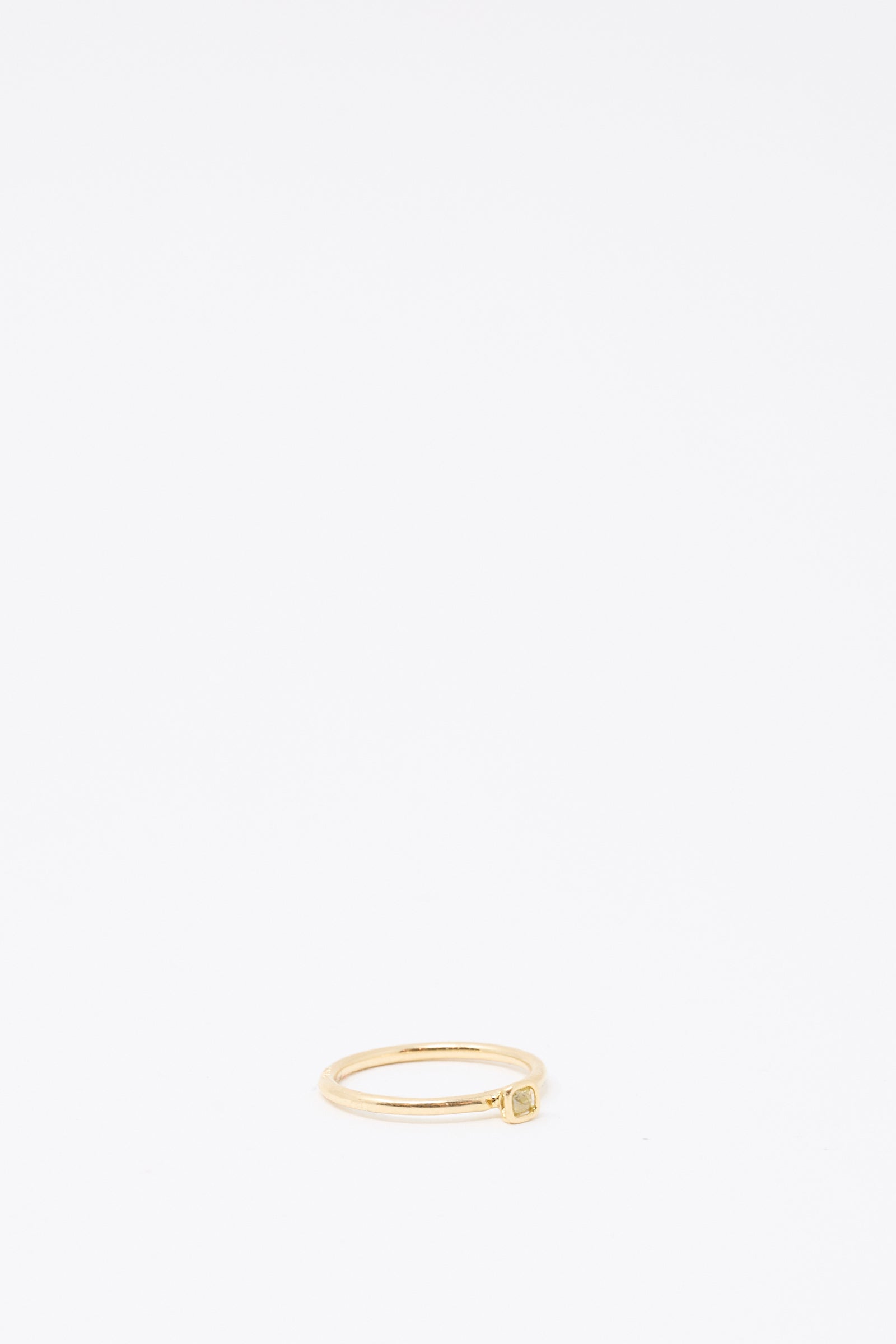 The Mary MacGill 14K Floating Ring in Petite Light Green Rose Cut Mineral Diamond features a slim gold band with a petite, square setting and light green diamond, placed near the bottom center of a plain white background.
