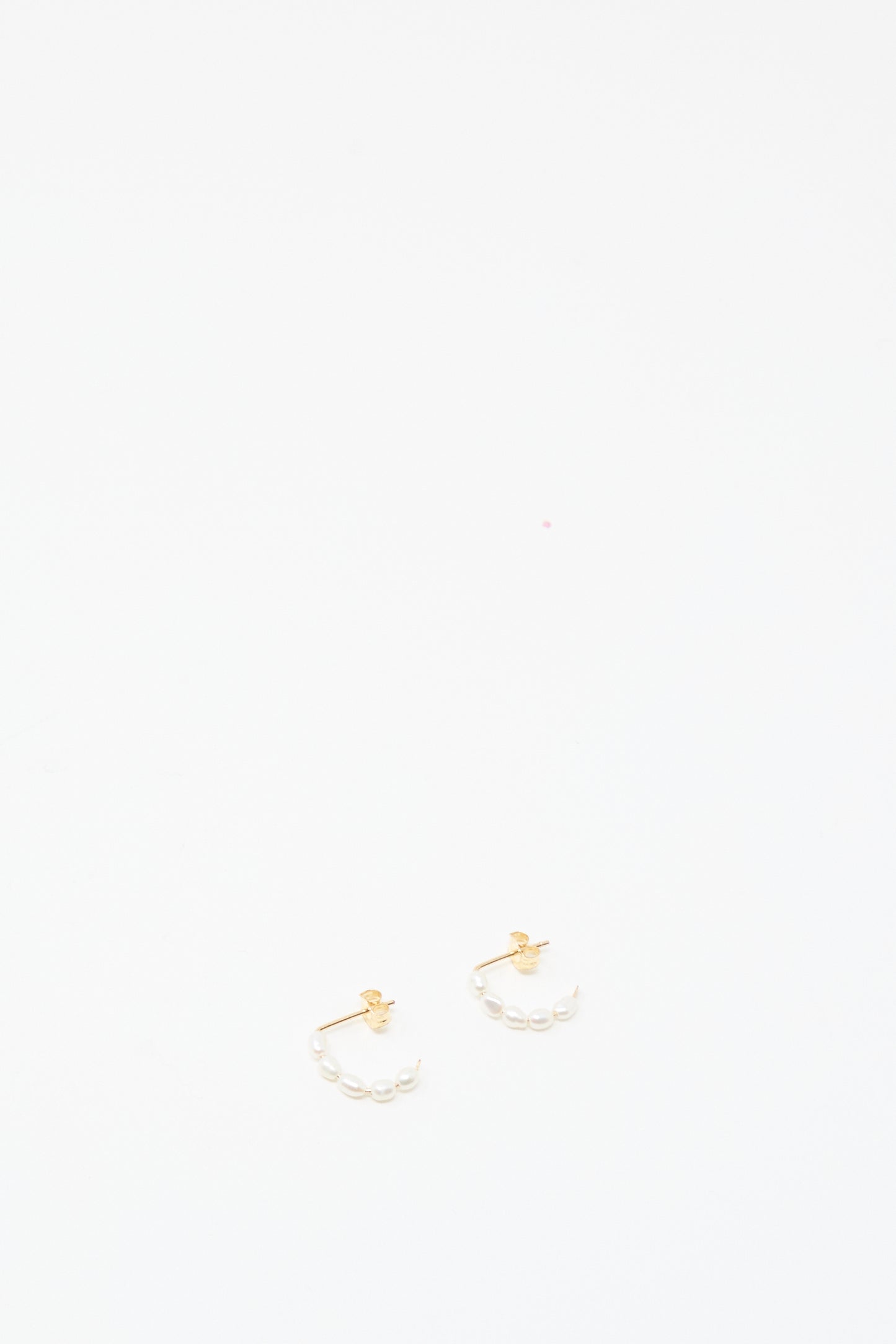 The Mary MacGill Baroque Pearl Crescent Hoops are small handmade gold earrings with baroque pearl accents, shown against a plain white background.