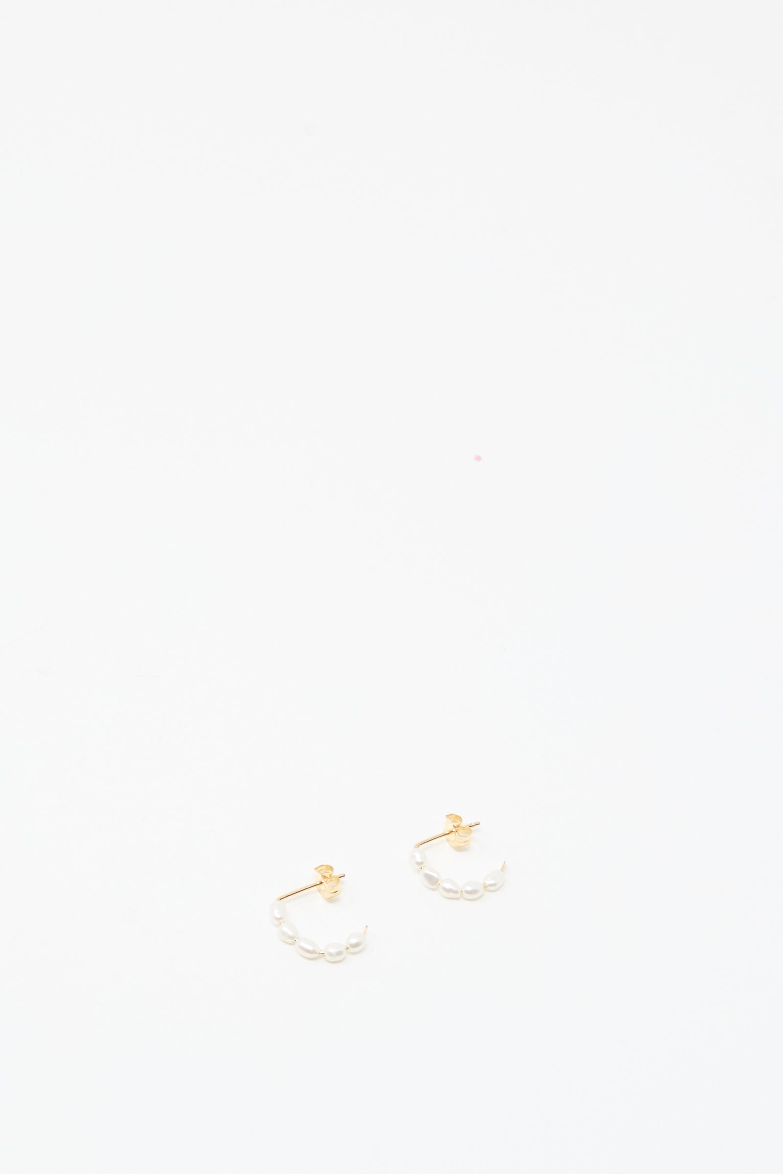 The Mary MacGill Baroque Pearl Crescent Hoops are small handmade gold earrings with baroque pearl accents, shown against a plain white background.