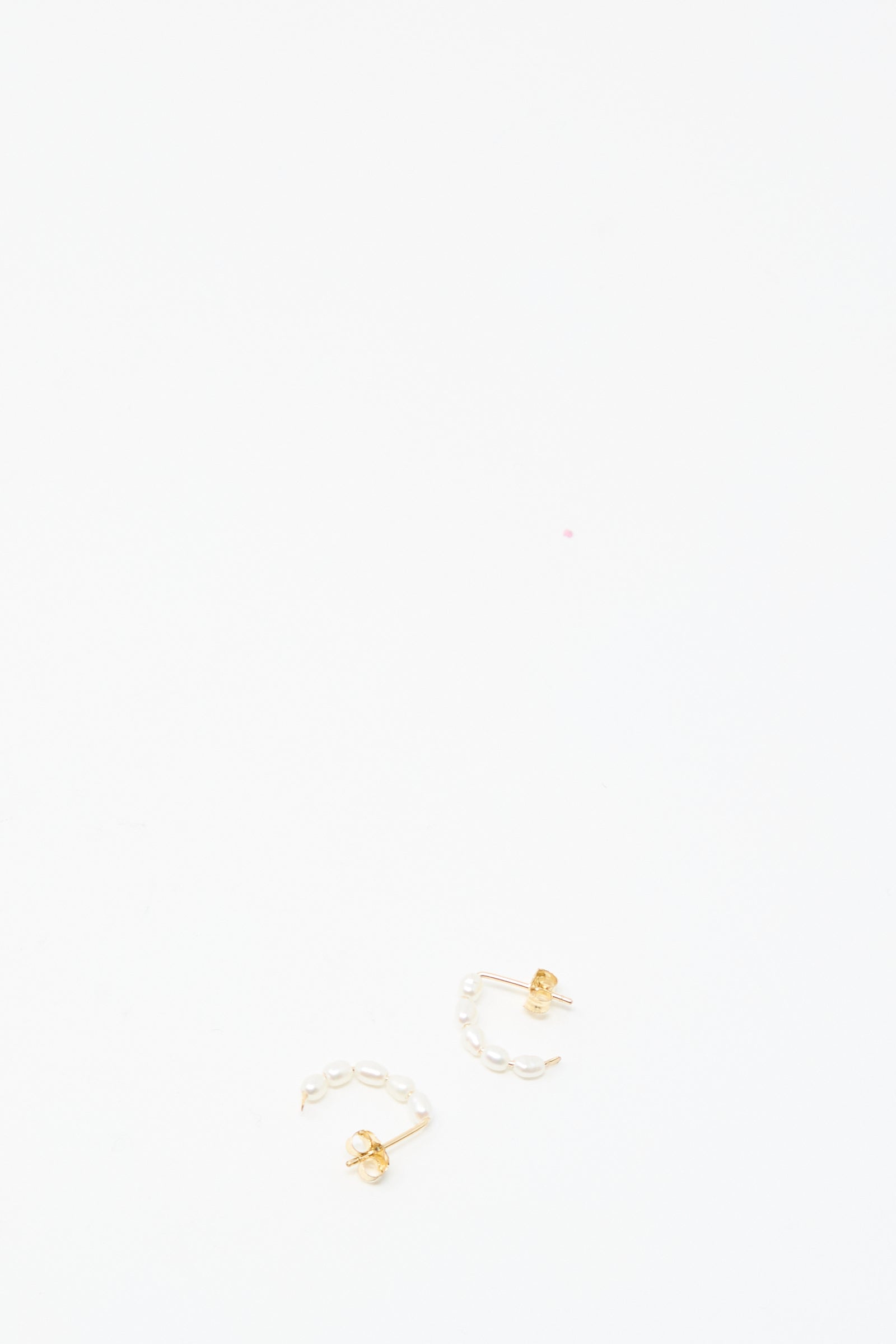 Mary MacGill's Baroque Pearl Crescent Hoops are handmade earrings featuring gold studs and small pearls in a curved design, inspired by Baroque styles and shown on a plain white background.