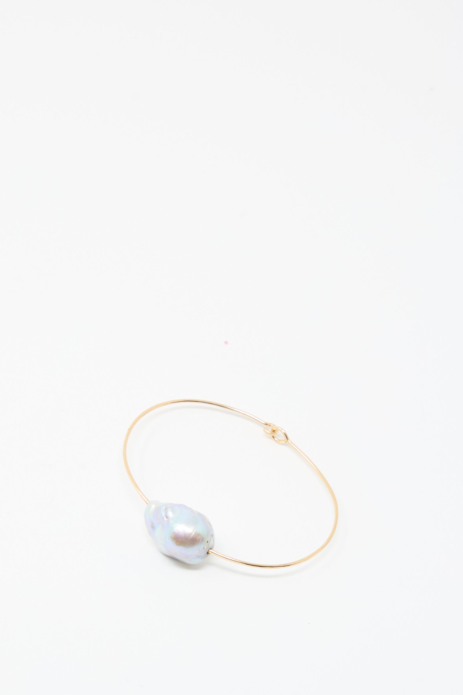 The Mary MacGill Baroque Pearl Cuff Bracelet in Silver is a handmade piece featuring a single large, irregularly shaped baroque pearl, elegantly displayed on a plain white background.