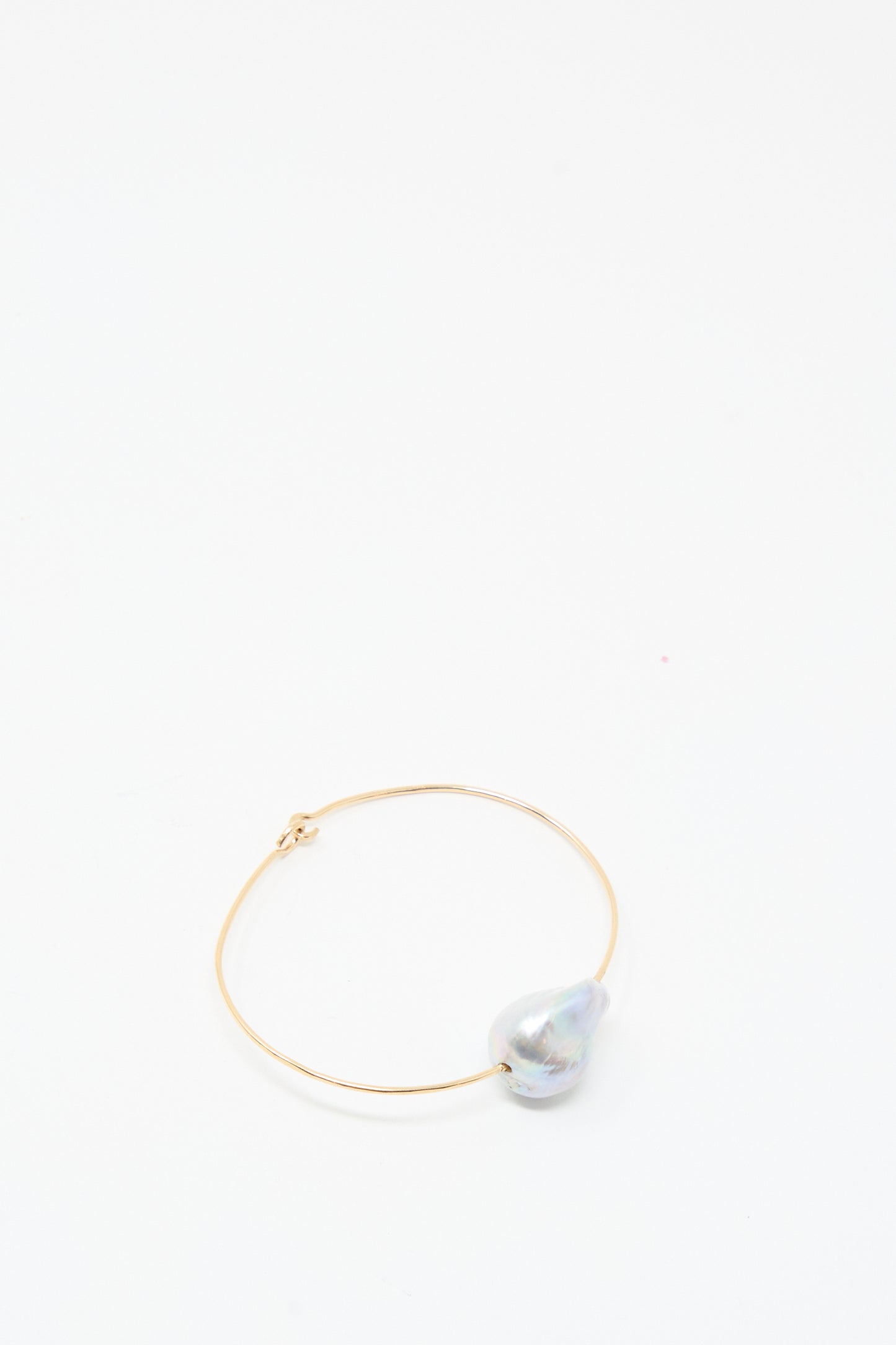 The Baroque Pearl Cuff Bracelet in Silver by Mary MacGill features a single large iridescent pearl and rests on a plain white background.
