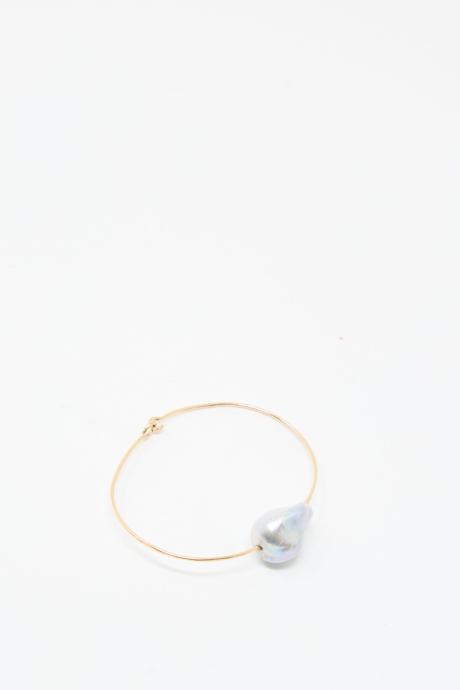 The Baroque Pearl Cuff Bracelet in Silver by Mary MacGill features a single large iridescent pearl and rests on a plain white background.