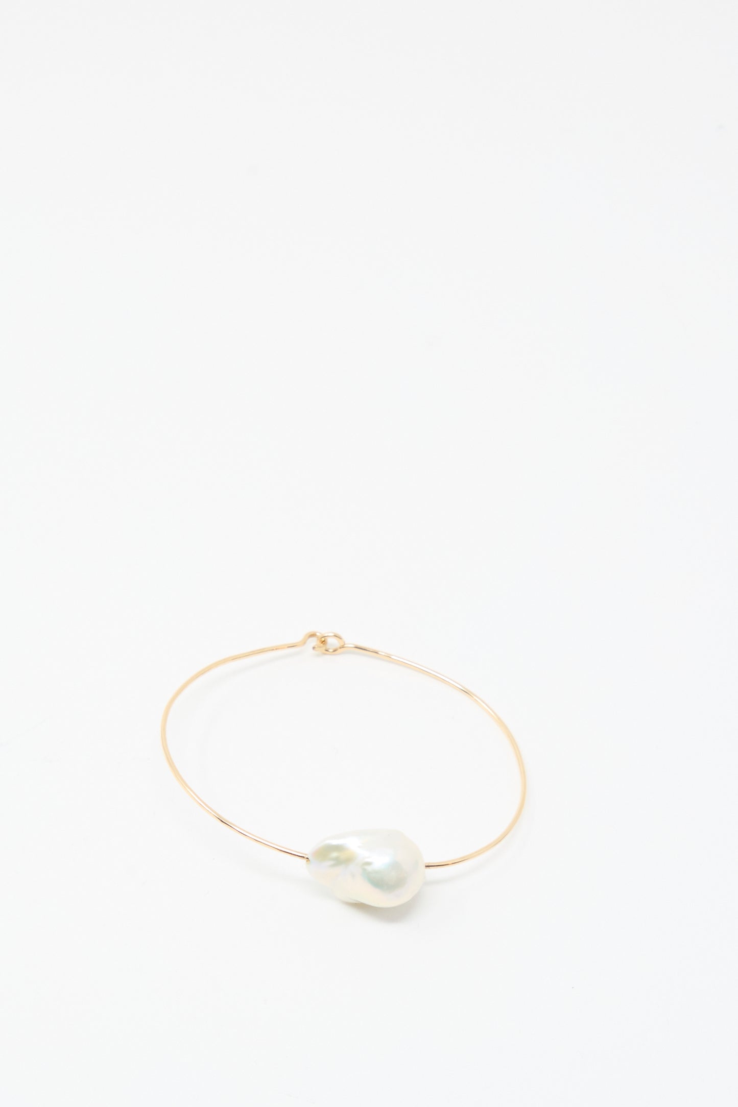 The Mary MacGill Baroque Pearl Cuff Bracelet in White features a thin gold-filled band with a large white Baroque pearl, shown on a plain white background.