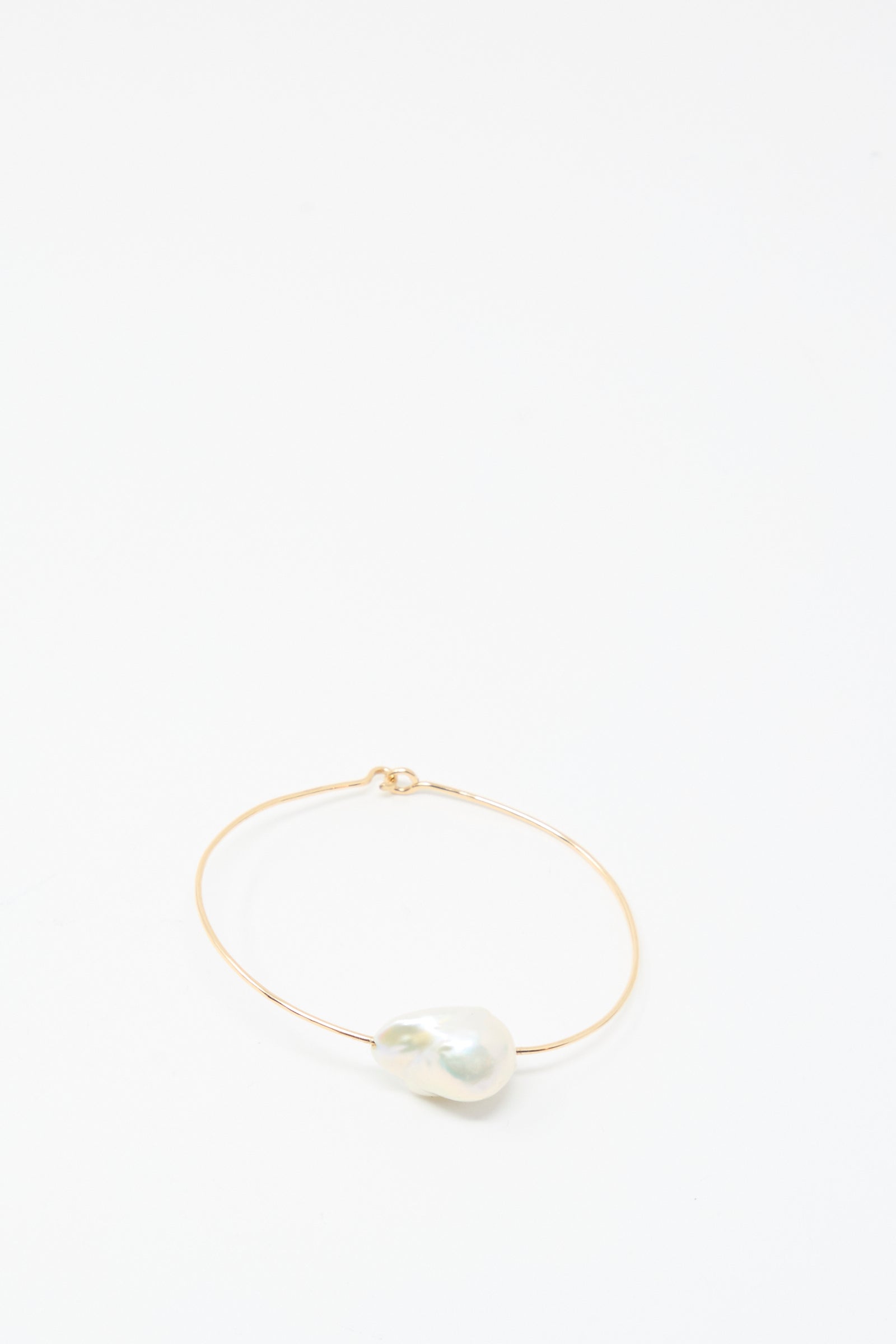 The Mary MacGill Baroque Pearl Cuff Bracelet in White features a thin gold-filled band with a large white Baroque pearl, shown on a plain white background.