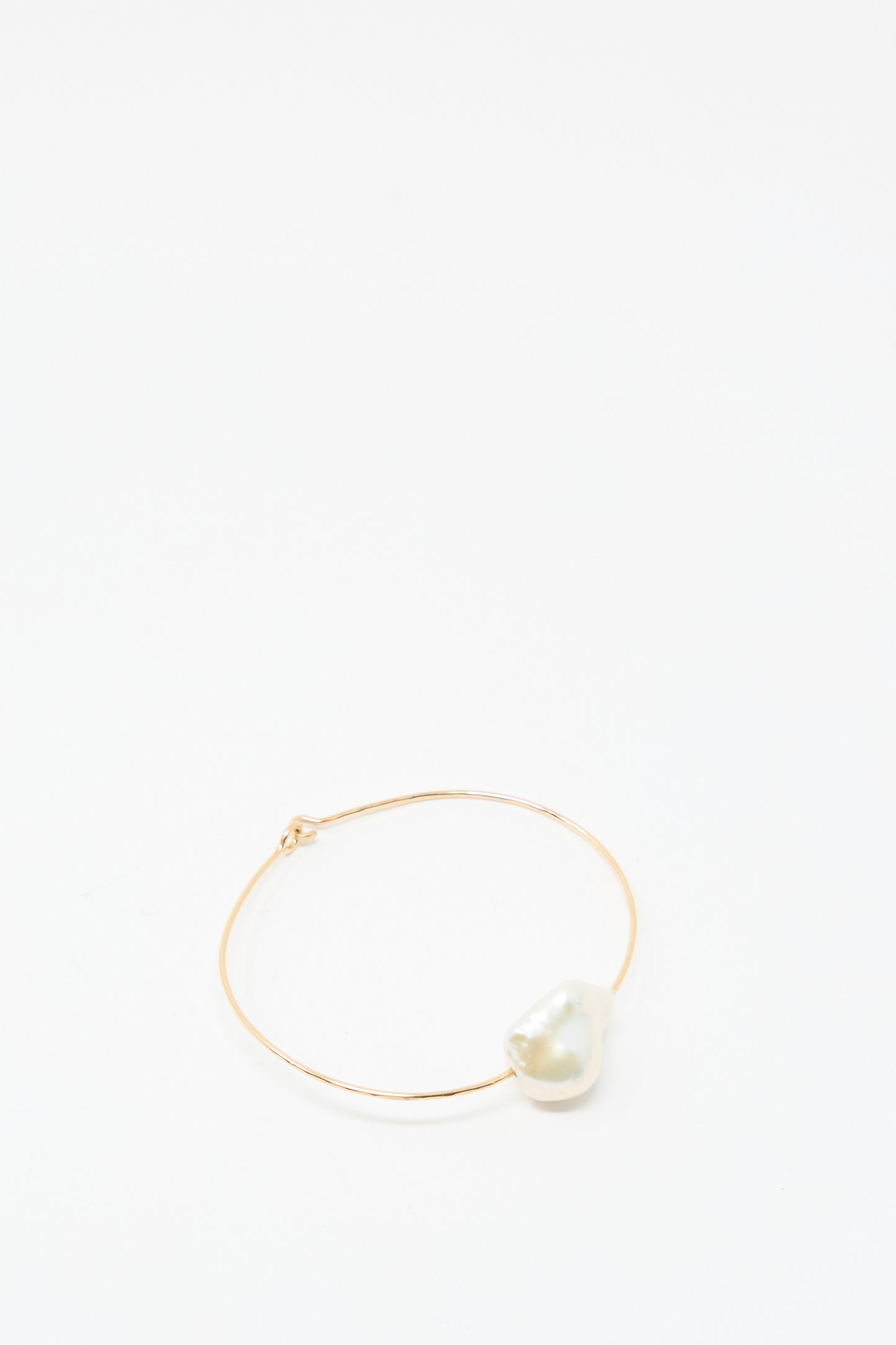The Mary MacGill Baroque Pearl Cuff Bracelet in White features a single large, irregular Baroque pearl on a slim gold-filled band, presented on a plain white background.