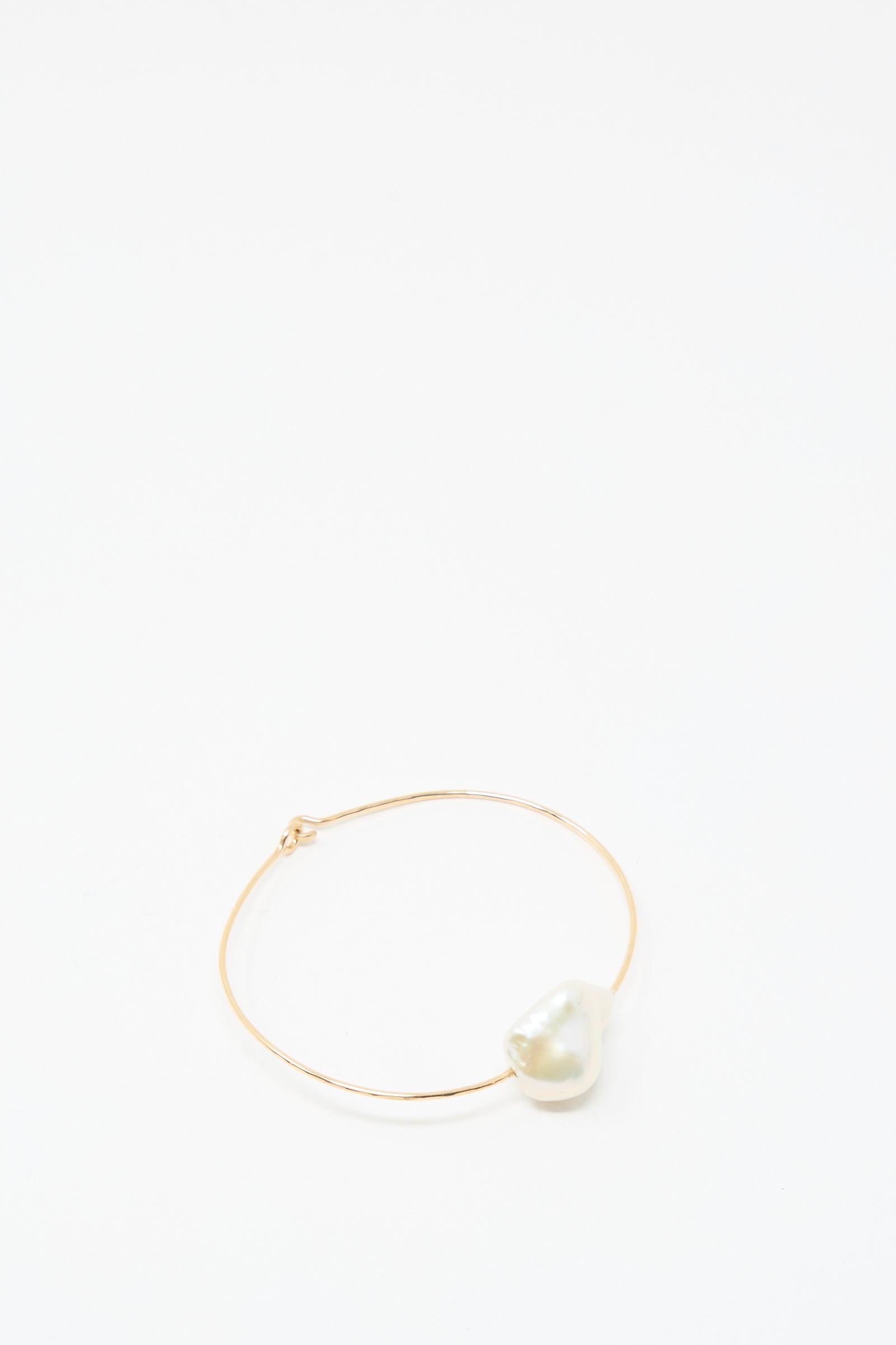 The Mary MacGill Baroque Pearl Cuff Bracelet in White features a single large, irregular Baroque pearl on a slim gold-filled band, presented on a plain white background.