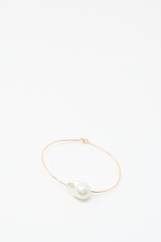The Mary MacGill Baroque Pearl Cuff Bracelet in White features a large white baroque pearl on a delicate gold-filled cuff, shown against a plain white background.