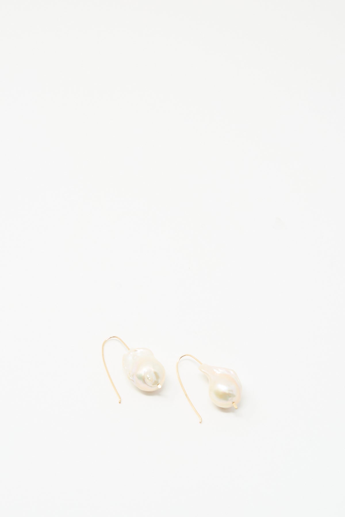 Baroque Pearl Drop Earrings in White by Mary MacGill feature single irregular baroque pearls on gold-filled hooks, shown on a plain white background.
