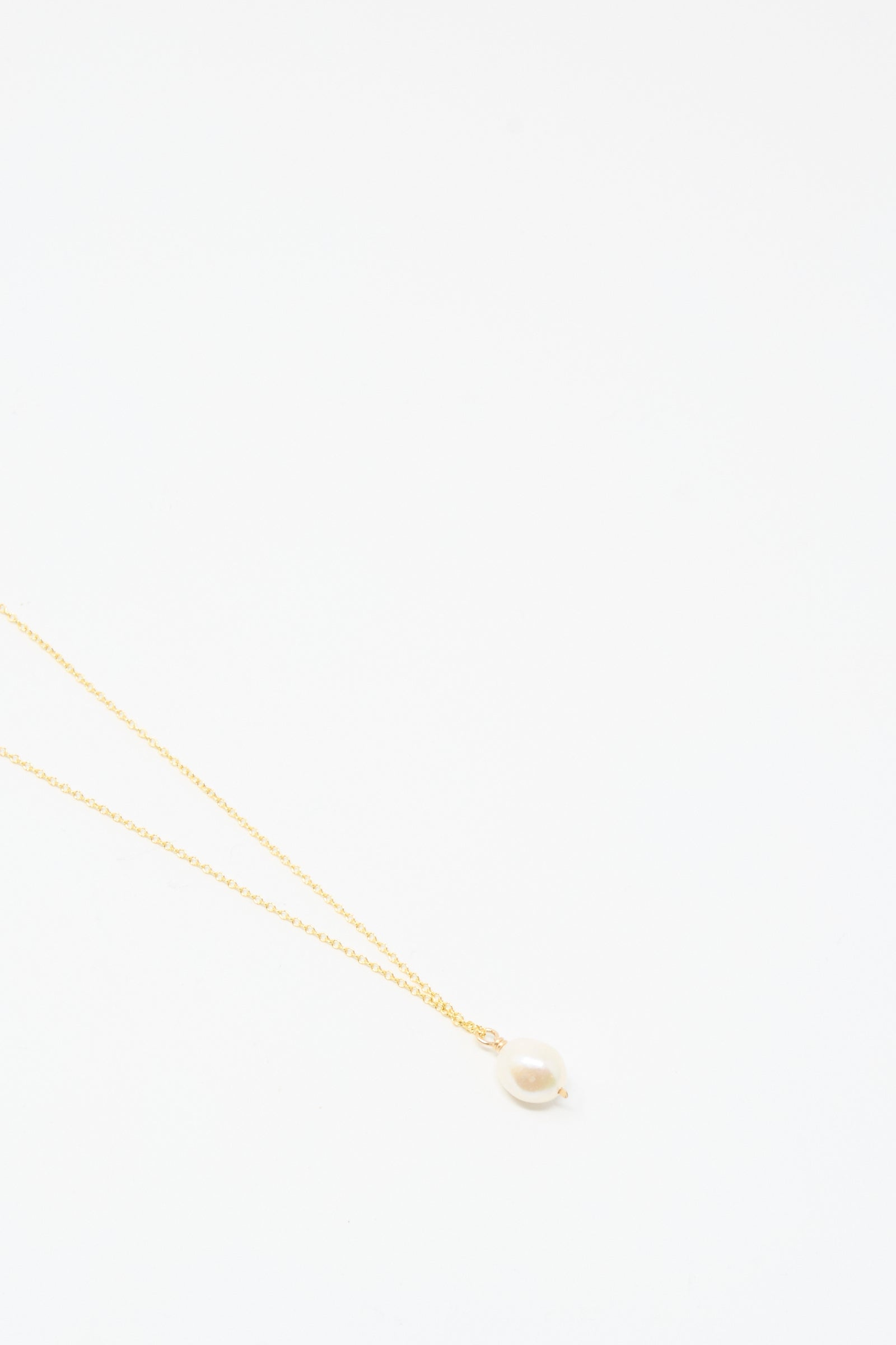 The Mary MacGill Baroque Pearl Drop Necklace in White, 18", features a handmade gold chain with a single baroque pearl pendant, shown on a simple white background.