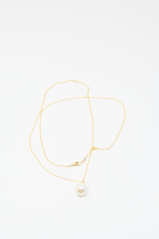 The Mary MacGill Baroque Pearl Drop Necklace in White (28") is a delicate handmade gold chain with a single round white pearl pendant, echoing classic baroque style, shown on a plain white background.