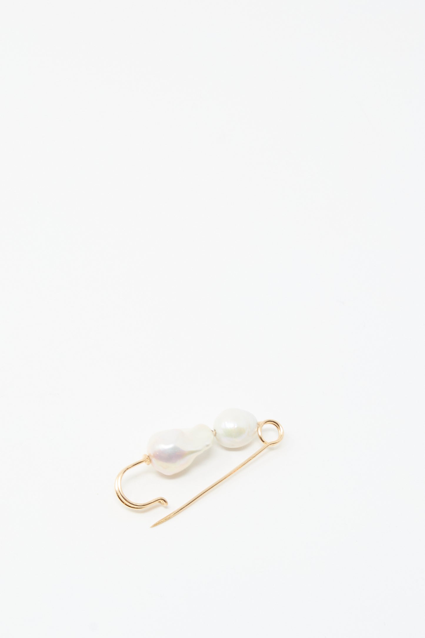 The Baroque Pearl Pin in White by Mary MacGill, featuring two irregular baroque pearls and handcrafted with gold-filled wire, is displayed on a simple white background.
