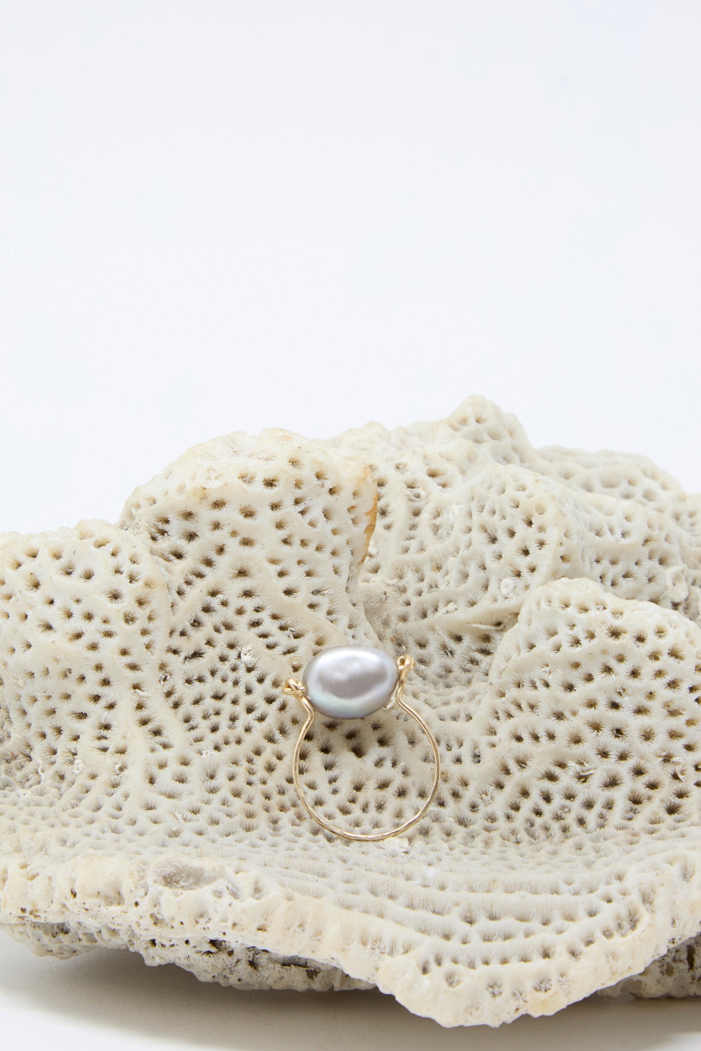 A Mary MacGill Baroque Pearl Ring in Silver, showcasing a handmade design with a Silver Baroque pearl placed on textured coral and a band made from gold-filled wire, all set against a plain white background.