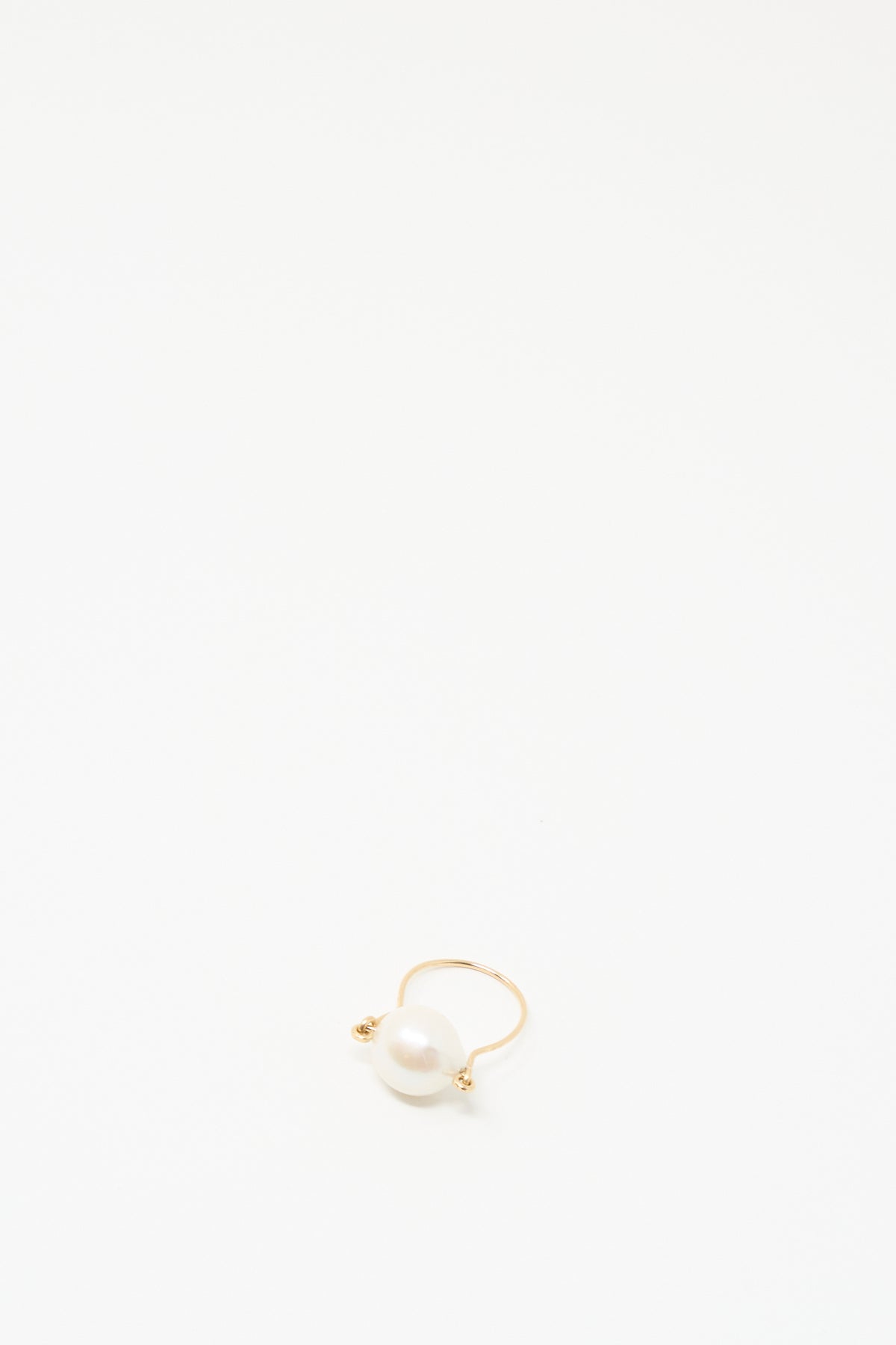 The Baroque Pearl Ring in White by Mary MacGill, featuring a single white pearl, is displayed on a plain white background.