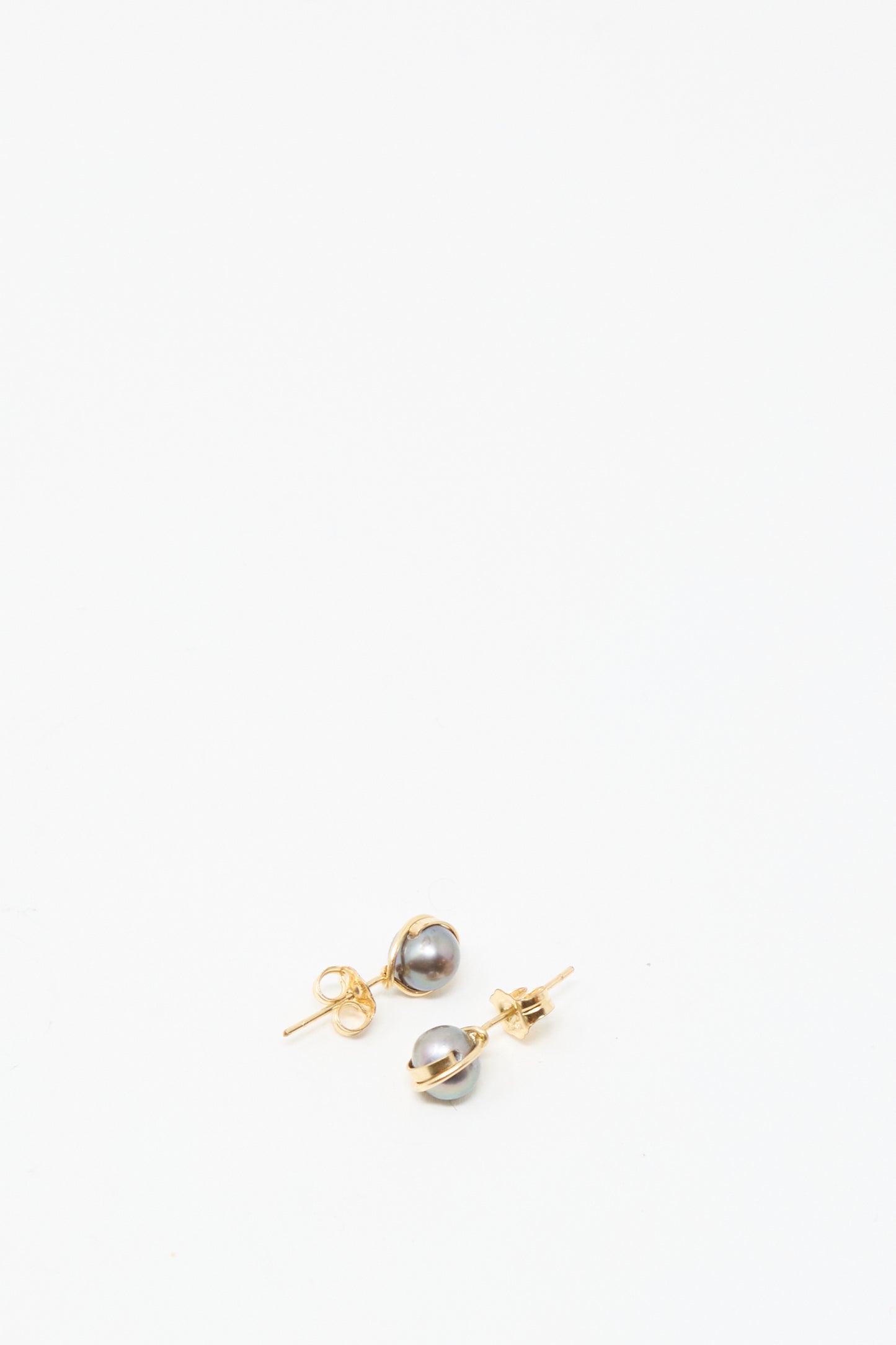 The Mary MacGill Baroque Pearl Studs in Charcoal feature round gray pearls on gold-filled posts, displayed against a plain white background—ideal for lovers of classic handmade earrings.