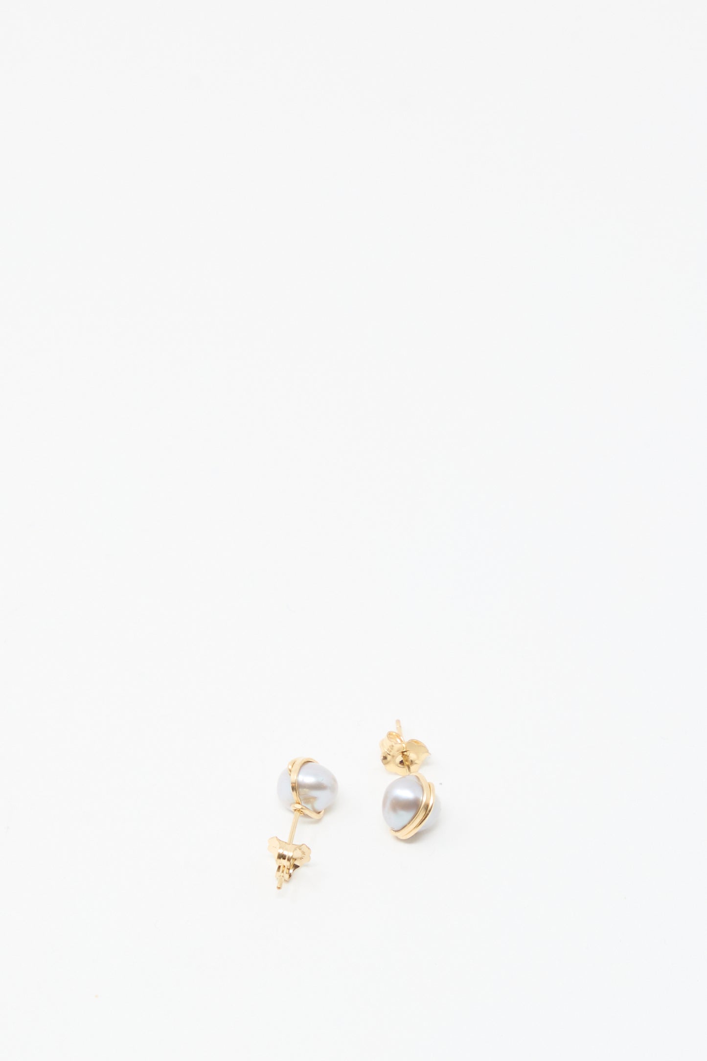 The Baroque Pearl Studs in Silver by Mary MacGill are small silver stud earrings featuring unique baroque pearls, displayed on a plain white background.