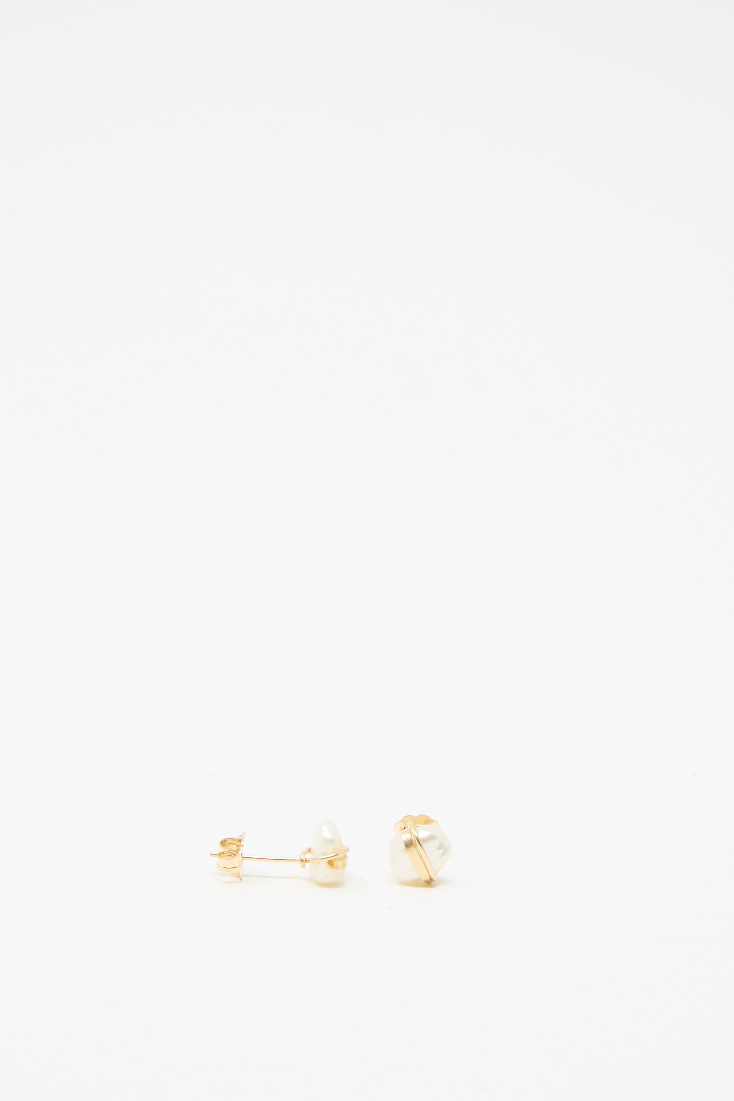 Baroque Pearl Studs in White by Mary MacGill, showcasing two baroque pearls on gold-filled posts, elegantly displayed against a plain white background.