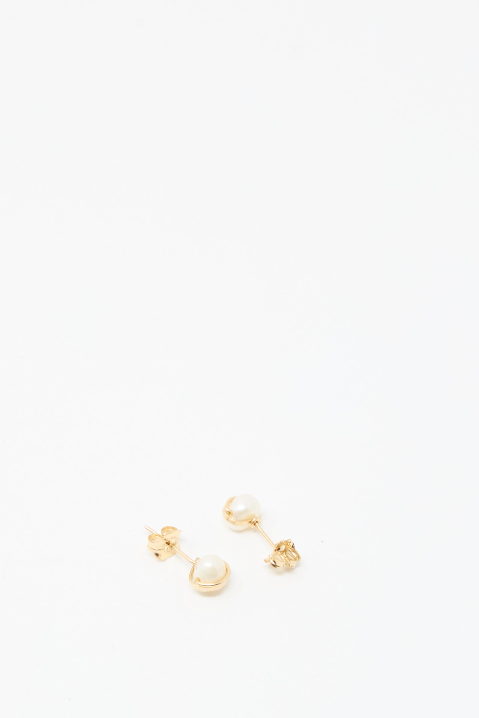 The Baroque Pearl Studs in White by Mary MacGill feature small gold-filled studs with white pearls, elegantly displayed on a plain white background.