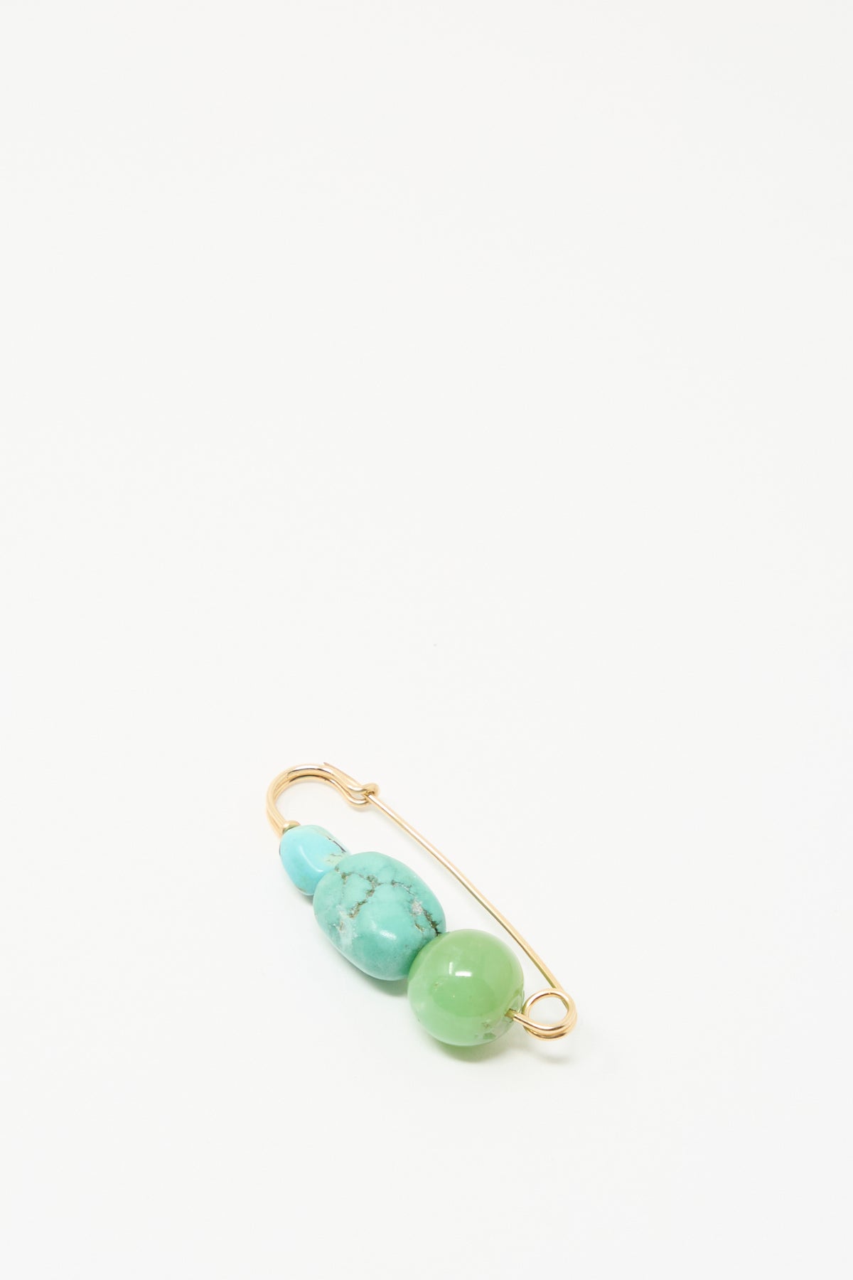 The Chrysoprase and Turquoise Pin by Mary MacGill features gold with turquoise and green beads, displayed on a plain white background.