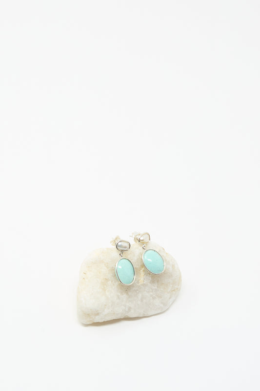 Double Stone Drop Earrings in Keshi Pearl and Turquoise by Mary MacGill, featuring oval turquoise stones set in silver, displayed on a white stone background—ideal for lovers of unique, handmade jewelry.