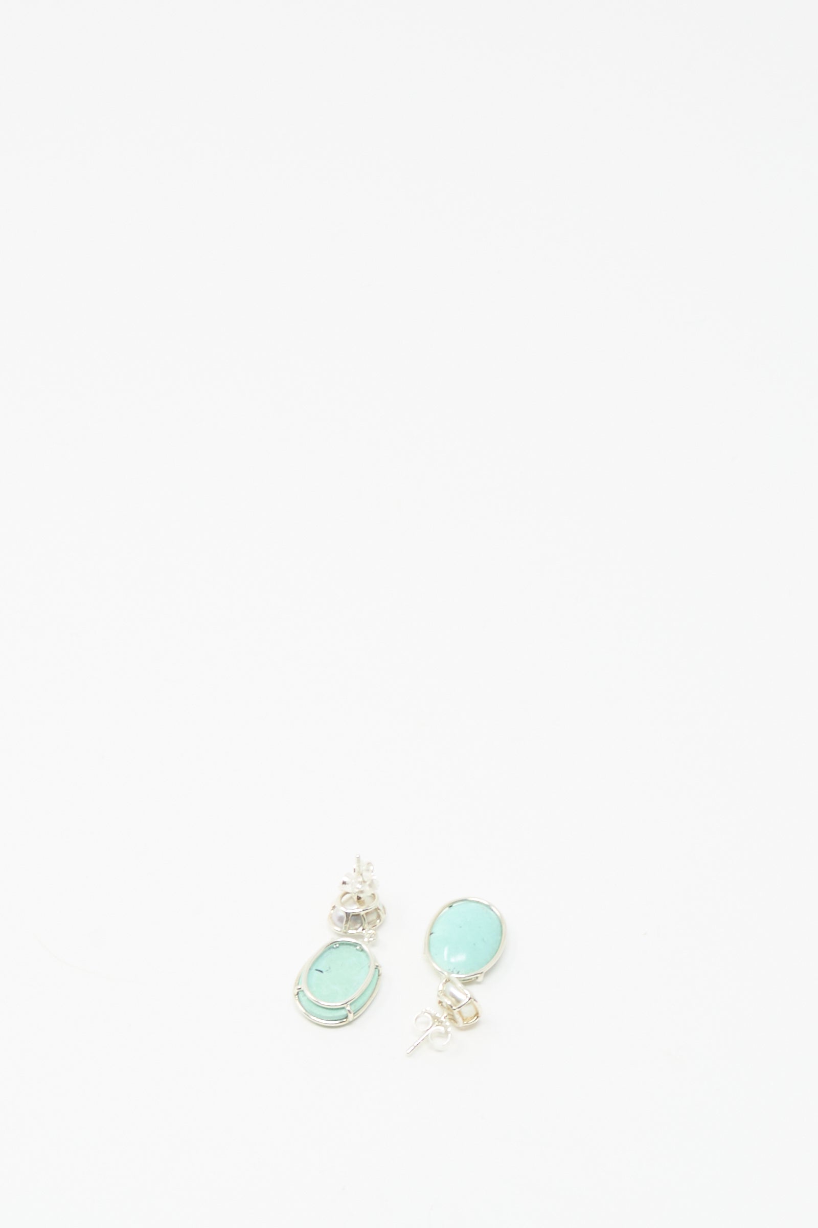 A pair of Double Stone Drop Earrings by Mary MacGill, featuring small turquoise and Keshi pearl stones, shown near the bottom center on a white background.