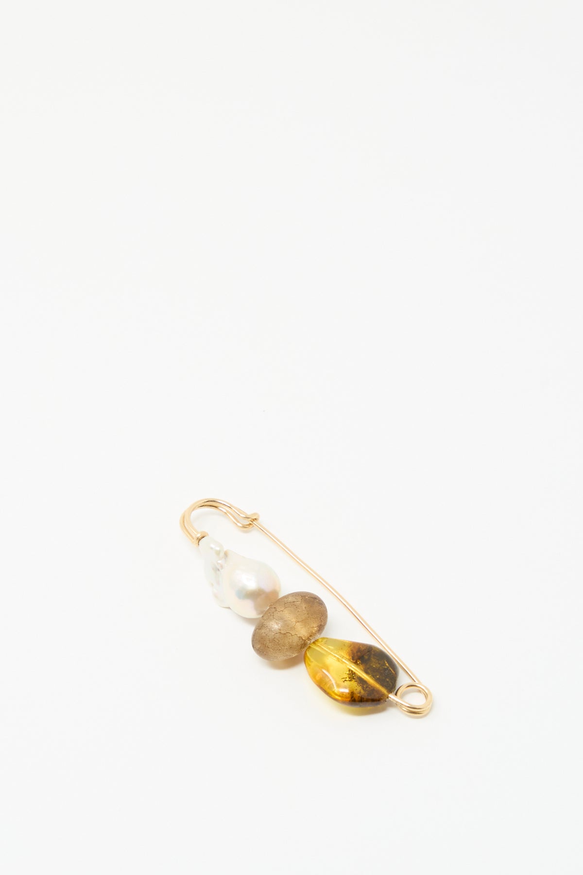 The Frosted Oak Pin by Mary MacGill features a baroque pearl, brown stone, and oval yellow gem on a gold-filled wire safety pin.