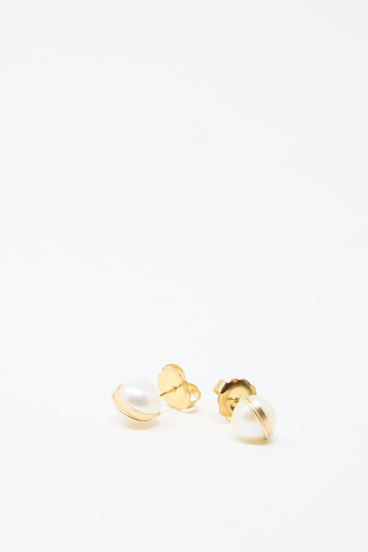 A pair of Grand Baroque Pearl Studs in white by Mary MacGill, crafted as handmade gold-filled stud earrings, showcasing Baroque pearls against a plain white backdrop.