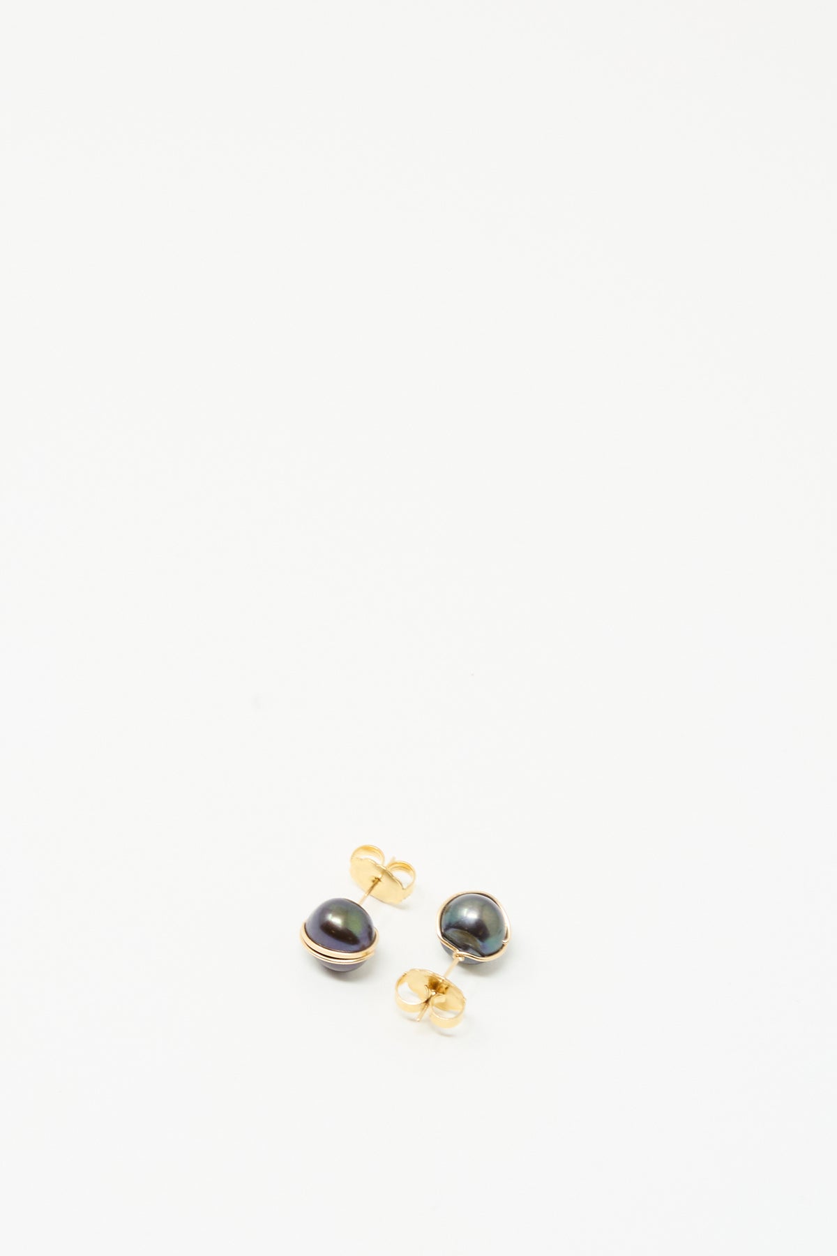 The Grande Baroque Pearl Studs in Charcoal by Mary MacGill are handmade gold-filled earrings featuring dark round pearls on a white background.