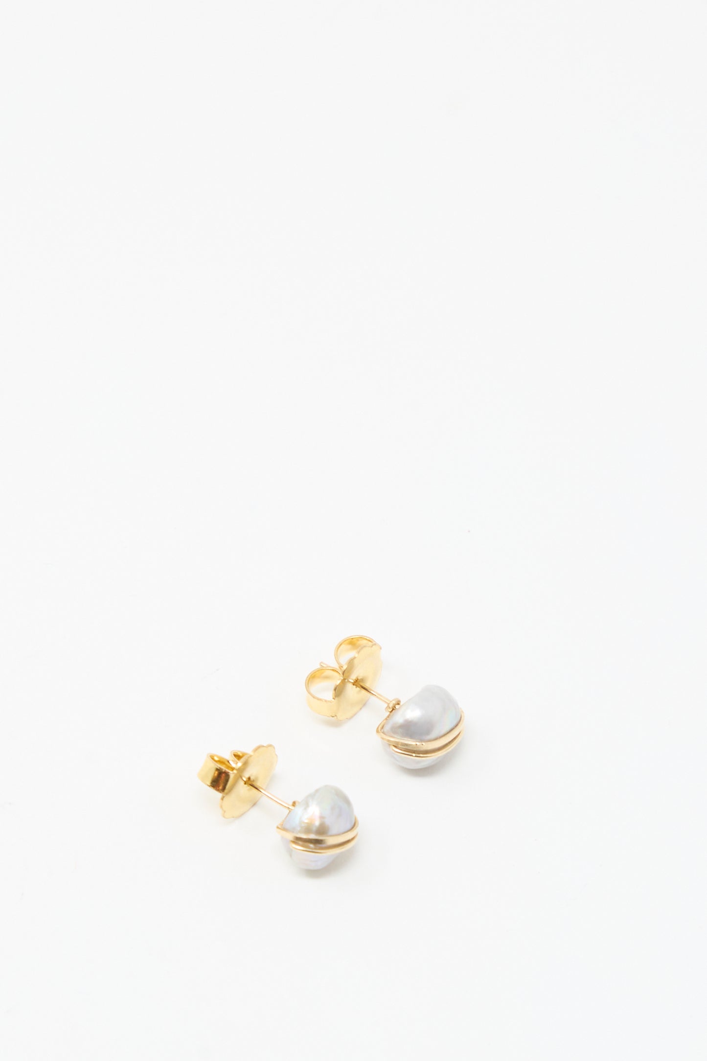 The Grande Baroque Pearl Studs in Silver by Mary MacGill feature irregularly shaped white baroque pearls set on silver studs, shown against a plain white background.