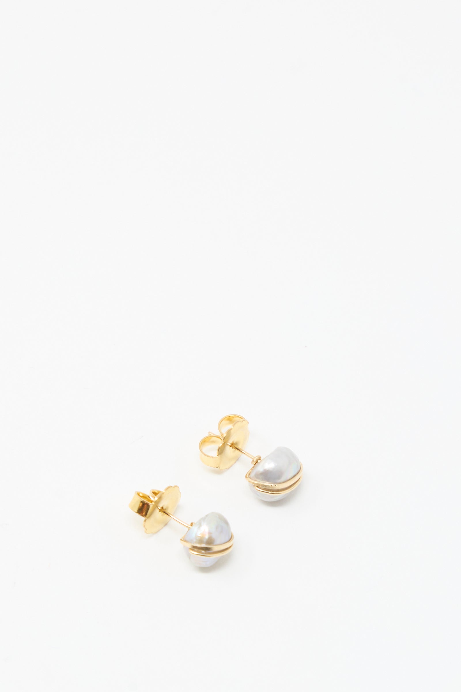 The Grande Baroque Pearl Studs in Silver by Mary MacGill feature irregularly shaped white baroque pearls set on silver studs, shown against a plain white background.