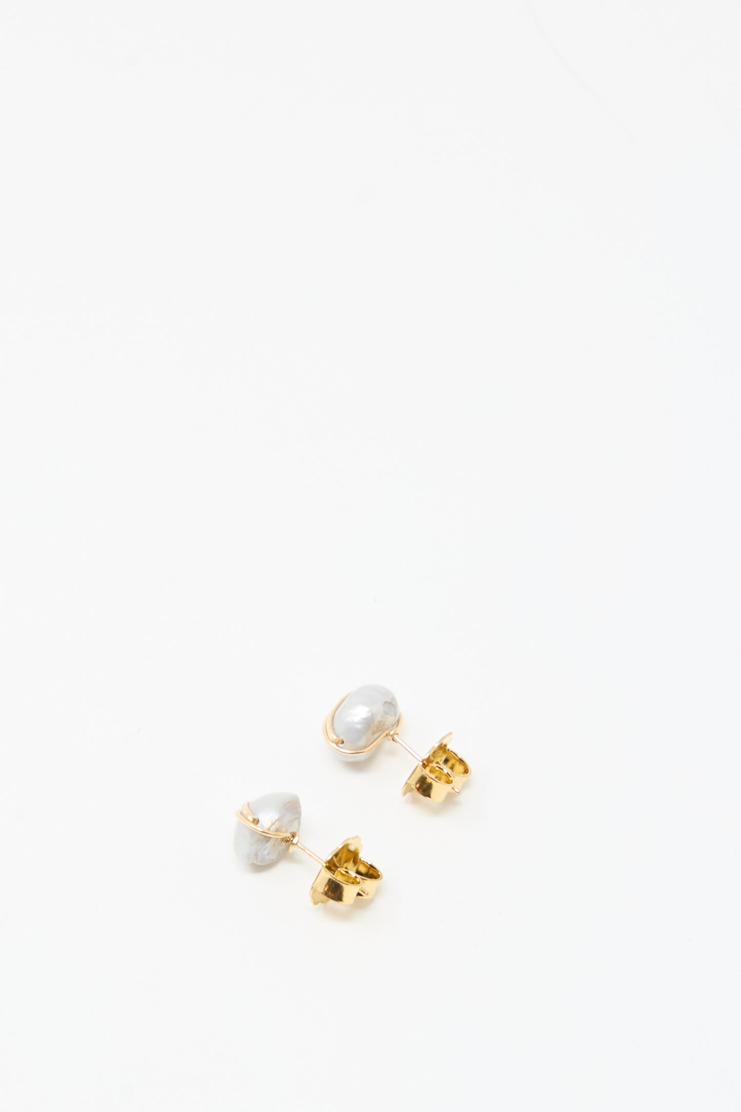 The Mary MacGill Grande Baroque Pearl Studs in Silver are handmade stud earrings featuring uniquely shaped baroque pearls, shown elegantly on a white background.