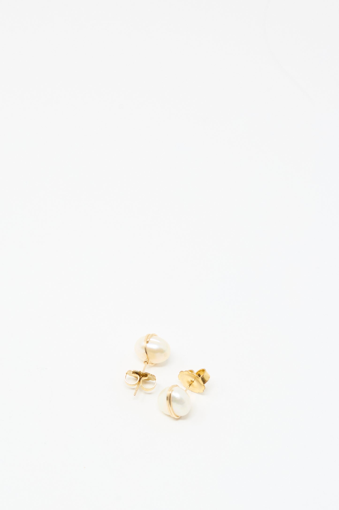 The Grande Baroque Pearl Studs in White by Mary MacGill are handmade gold-filled stud earrings featuring white pearl accents, shown on a plain white background.