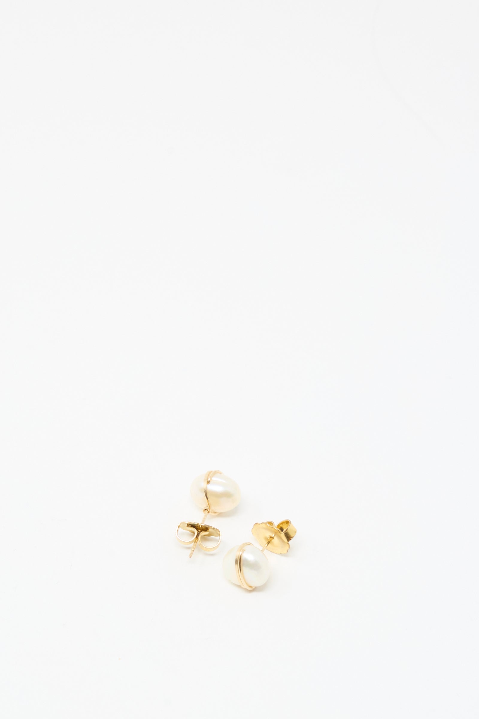 The Grande Baroque Pearl Studs in White by Mary MacGill are handmade gold-filled stud earrings featuring white pearl accents, shown on a plain white background.