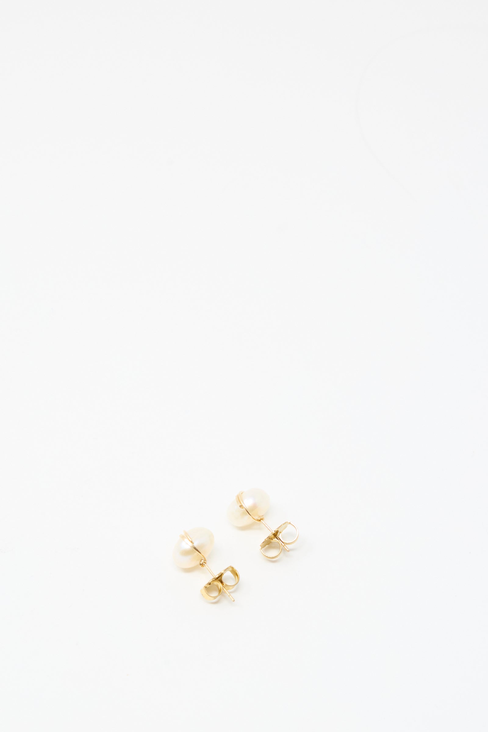 The Grande Baroque Pearl Studs in White by Mary MacGill are handmade gold-filled wire earrings featuring small white pearls, shown on a plain white background.