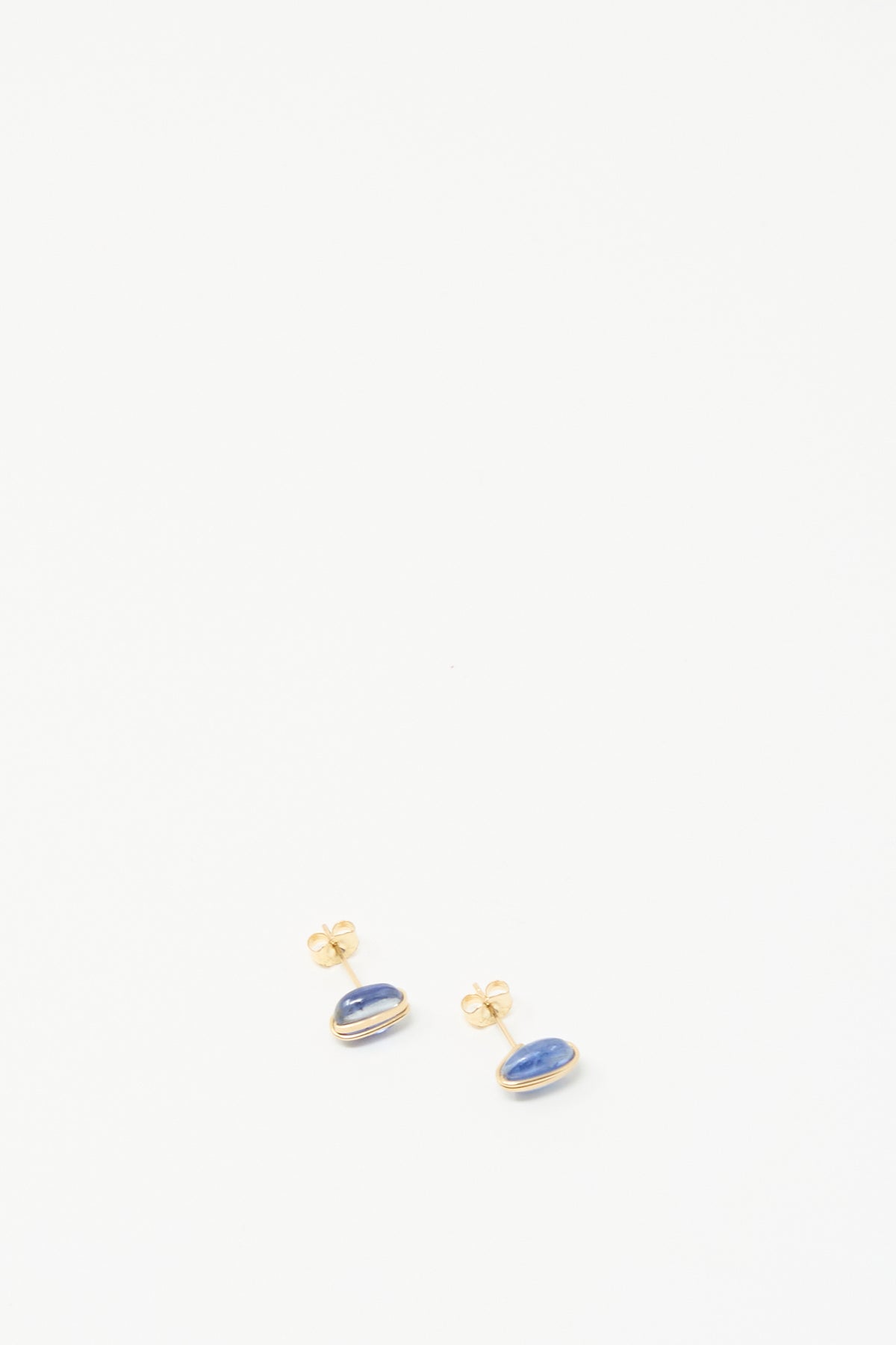 Mary MacGill Kyanite Studs: handmade earrings featuring oval blue stones in gold bezels, shown on a white background.