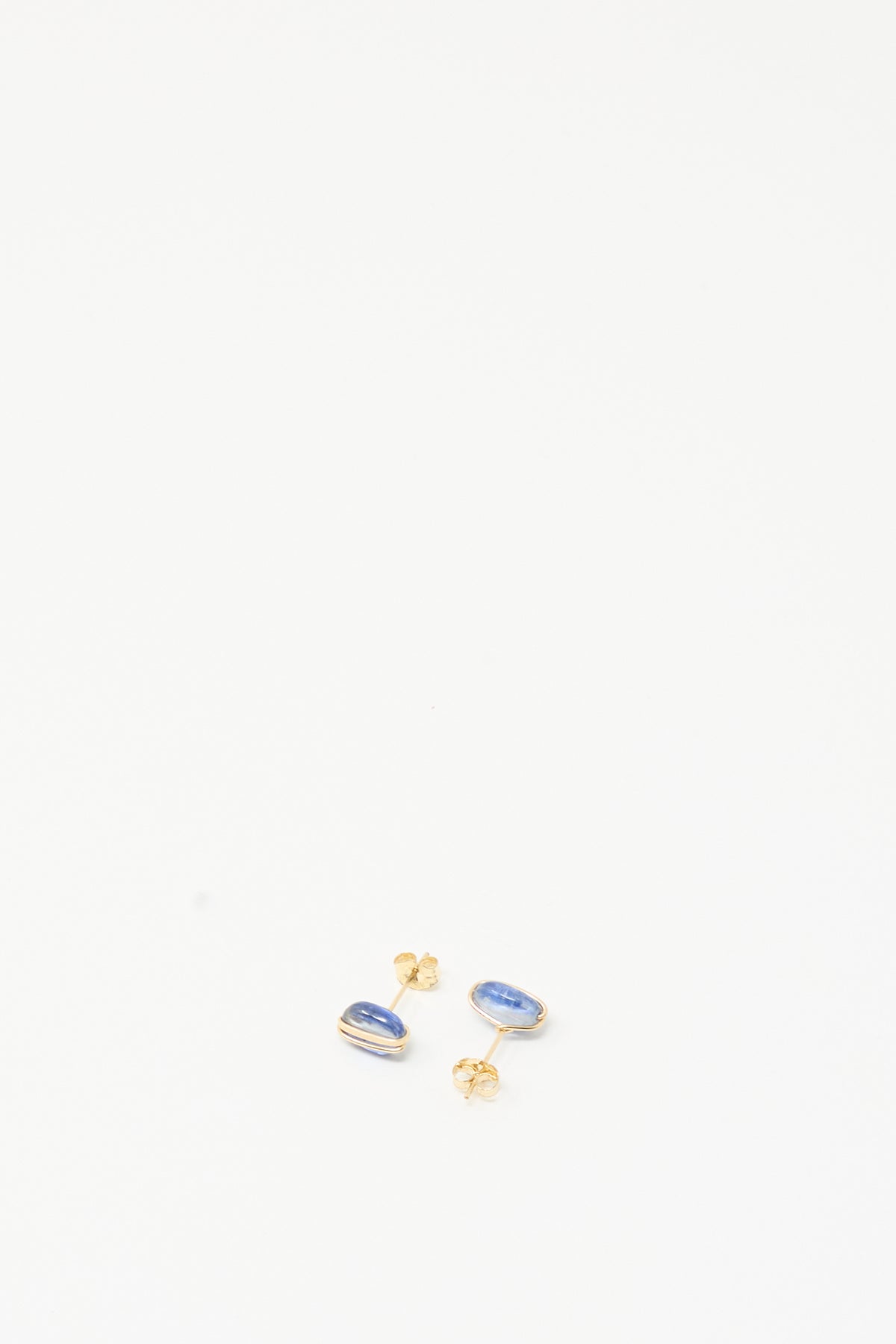 Kyanite Studs by Mary MacGill, handmade gold-filled earrings with small oval blue stones, rest near the bottom center against a plain white background.